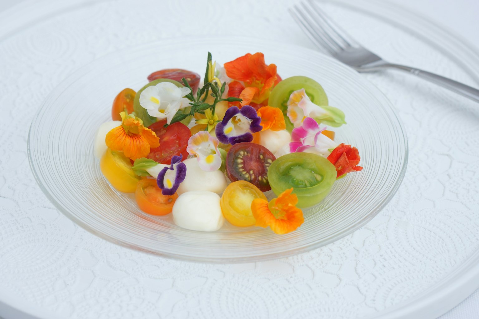 Salade colorée avec divers légumes et fruits disposés sur une assiette blanche