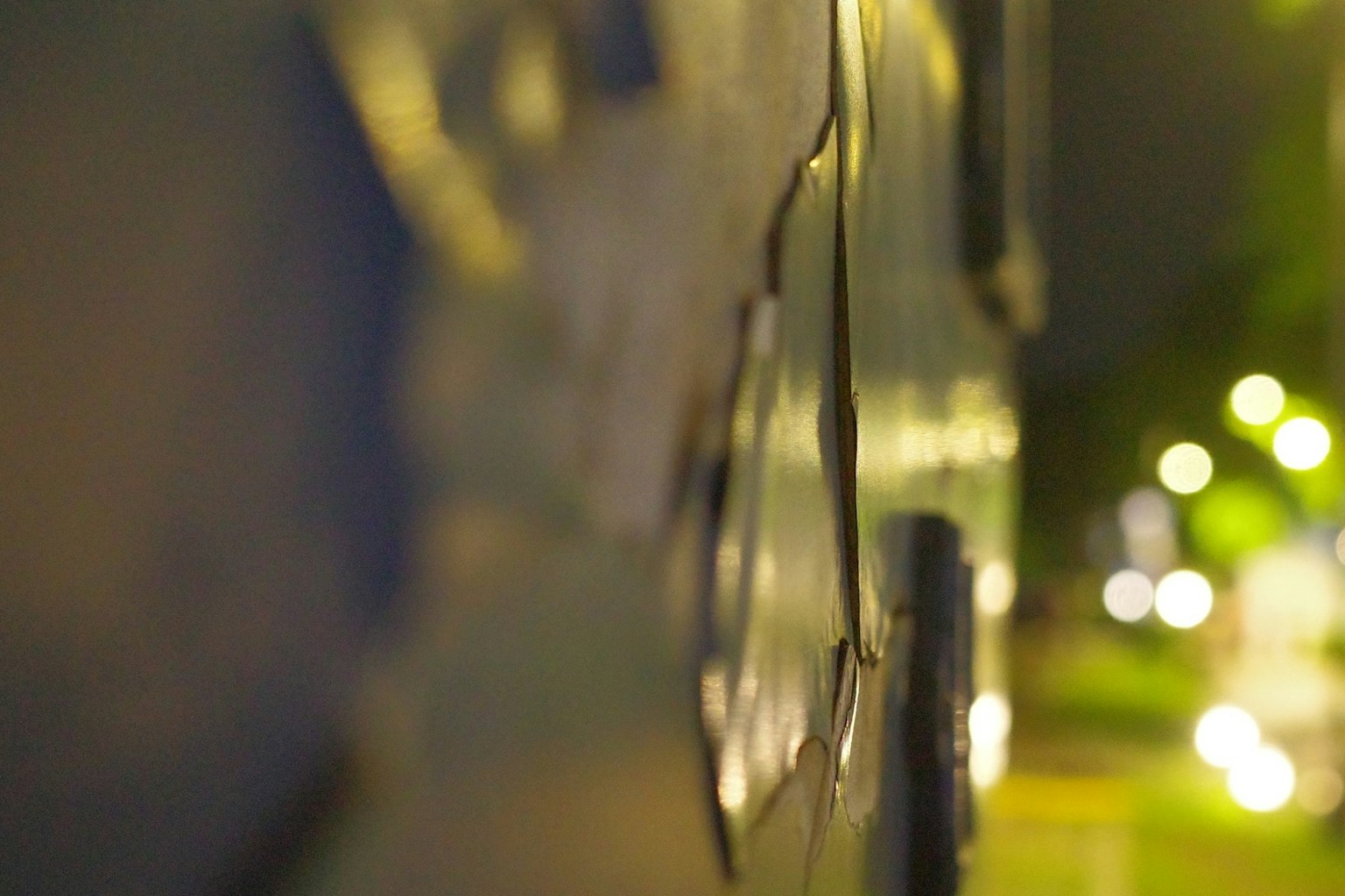 夜の街灯のぼやけた背景に焦点を当てた青い壁のクローズアップ