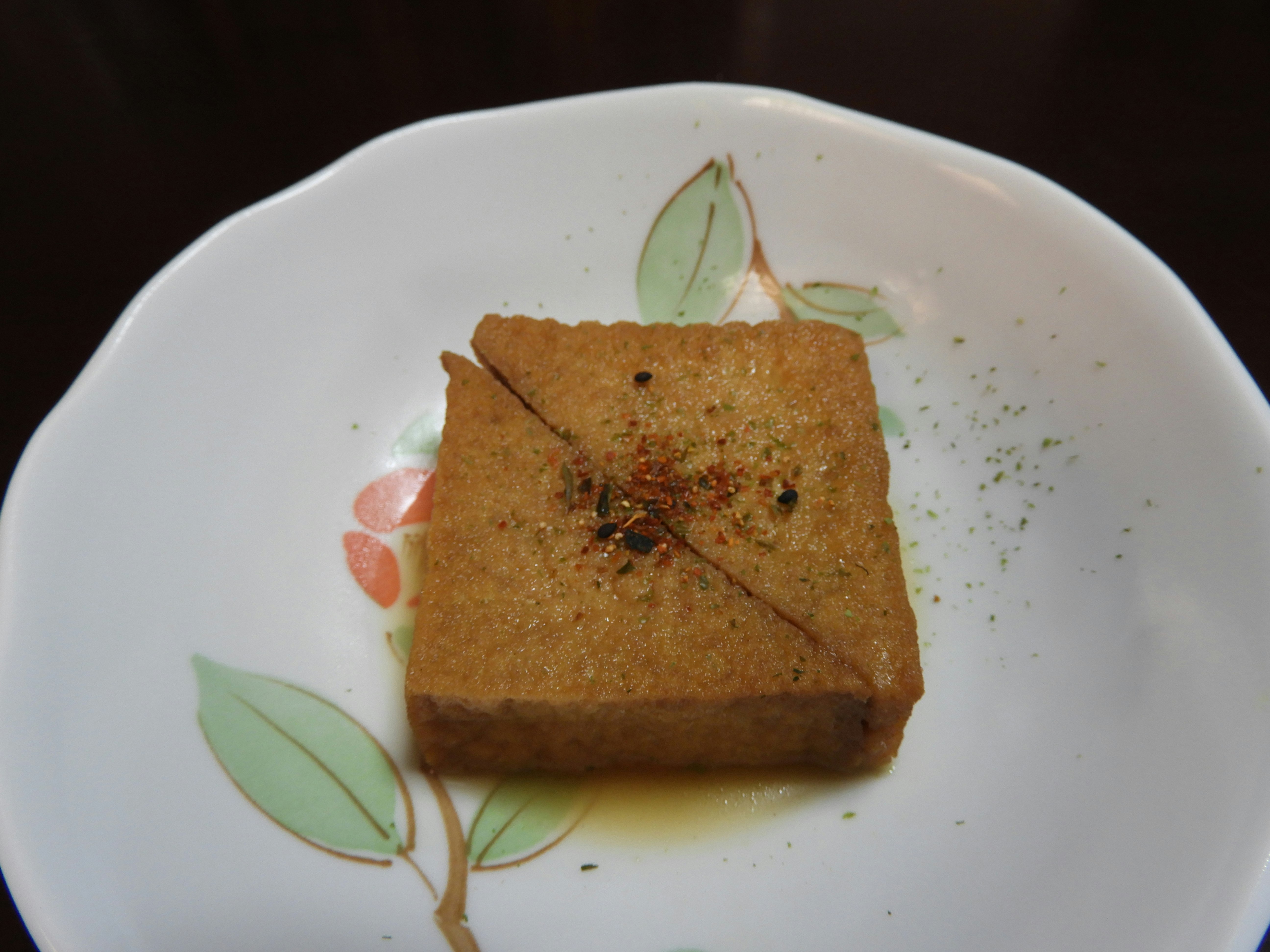 厚揚げの煮物を盛り付けた白い皿