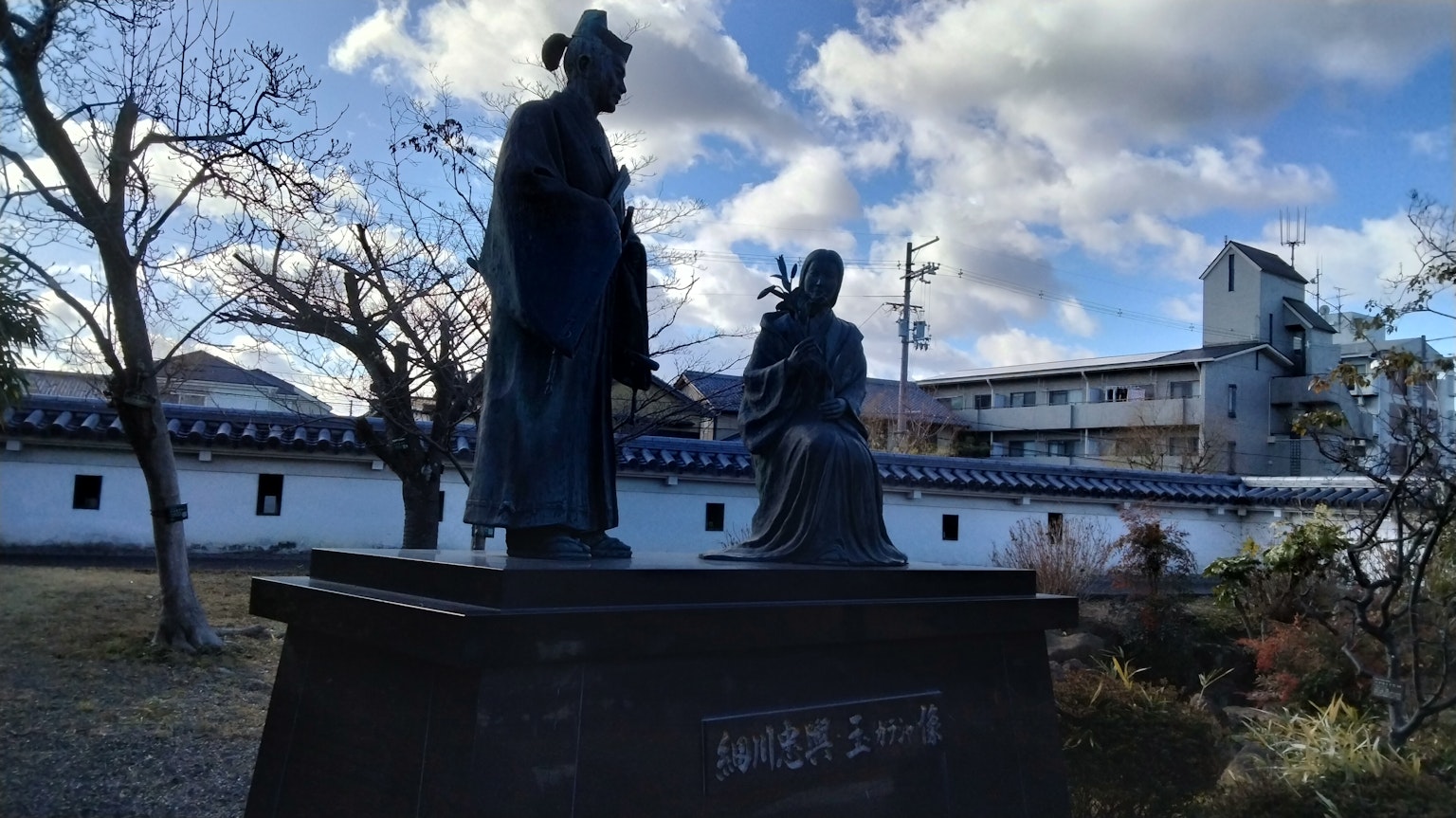 Two bronze statues in a garden setting