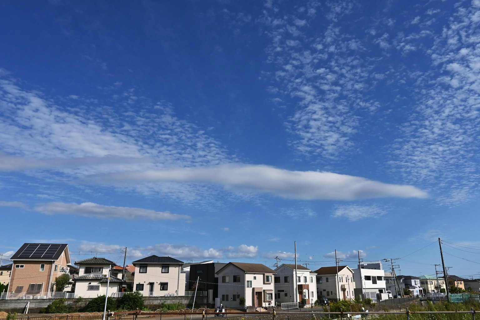 Wohngebiet mit Häusern unter blauem Himmel und Wolken