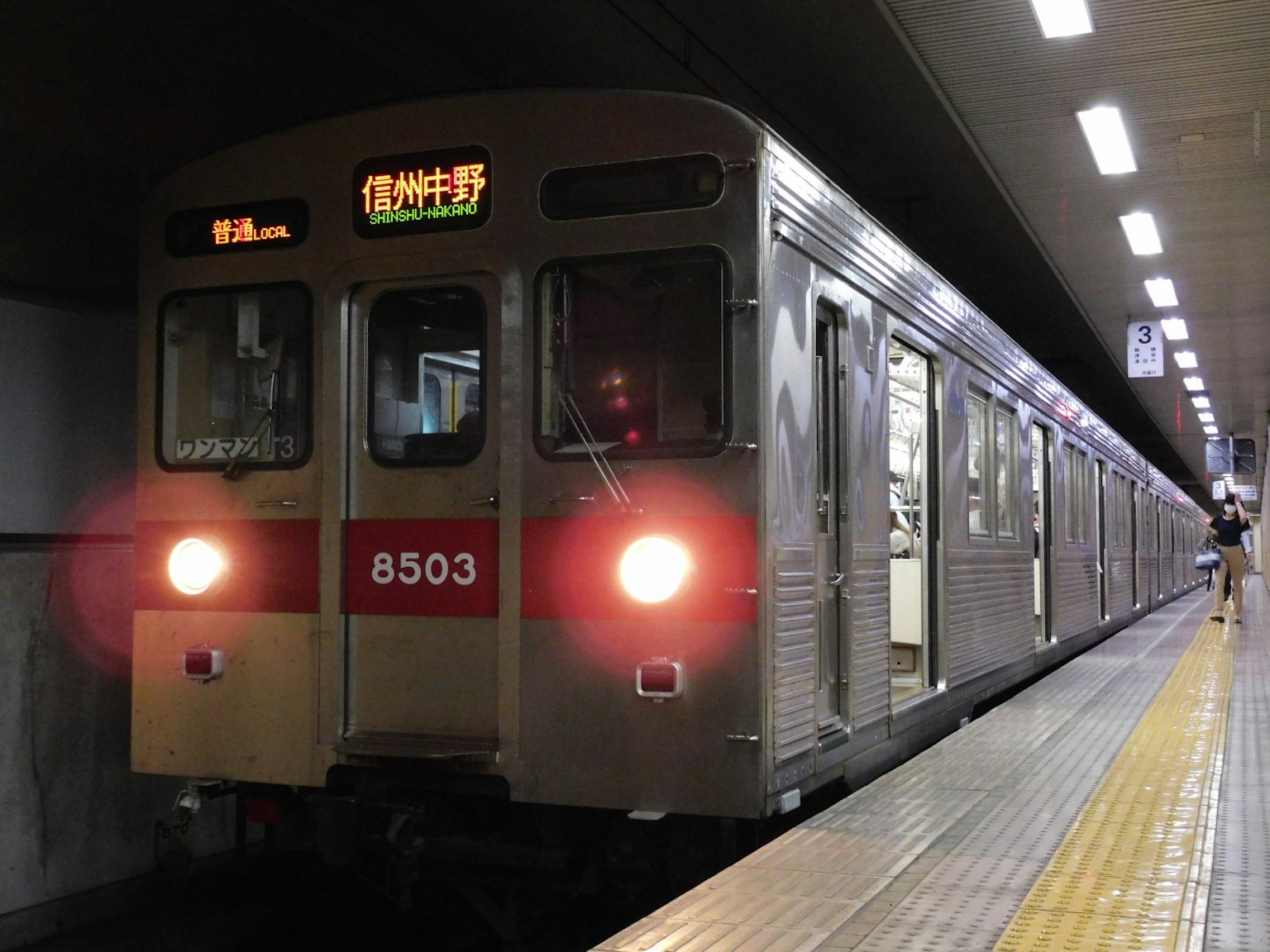 地鐵列車停靠在車站，帶有發光的目的地標誌
