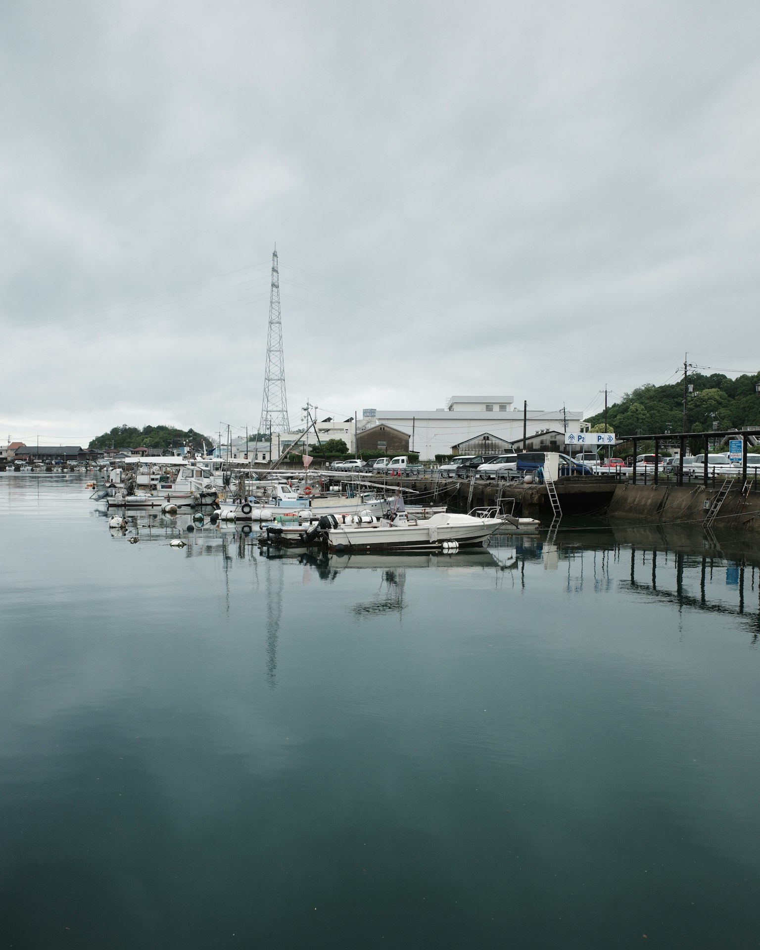 Ruhiger Hafen mit festgemachten Booten und bewölktem Himmel