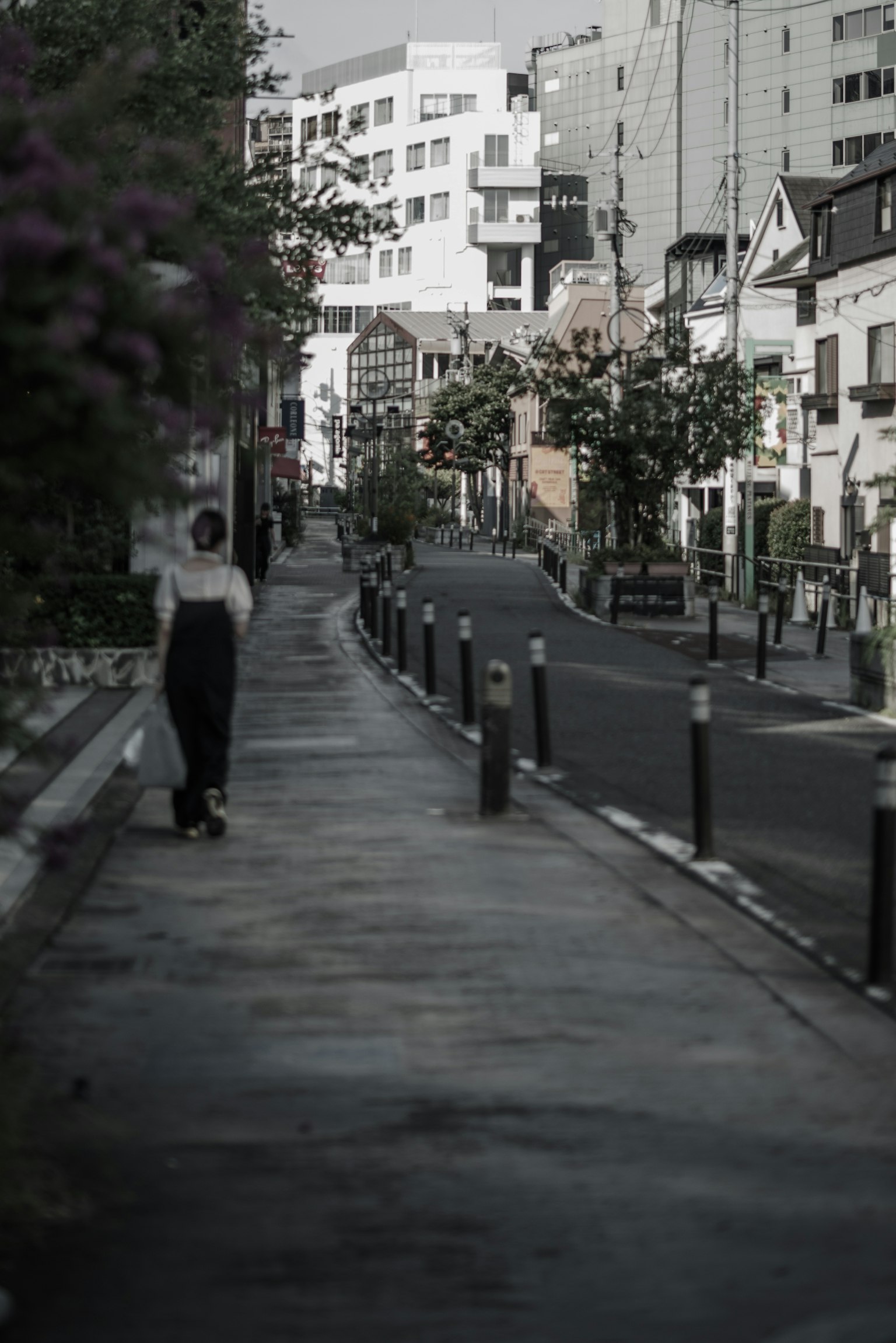 Eine Person, die auf einer ruhigen Straße mit umliegenden Gebäuden geht