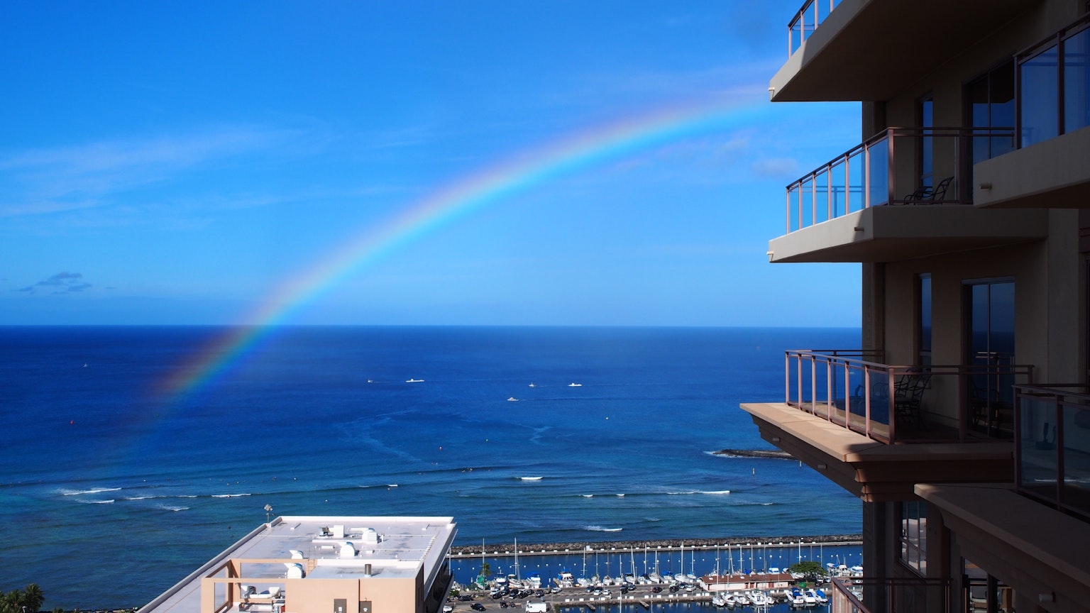 View of ocean and rainbow from a high-rise building