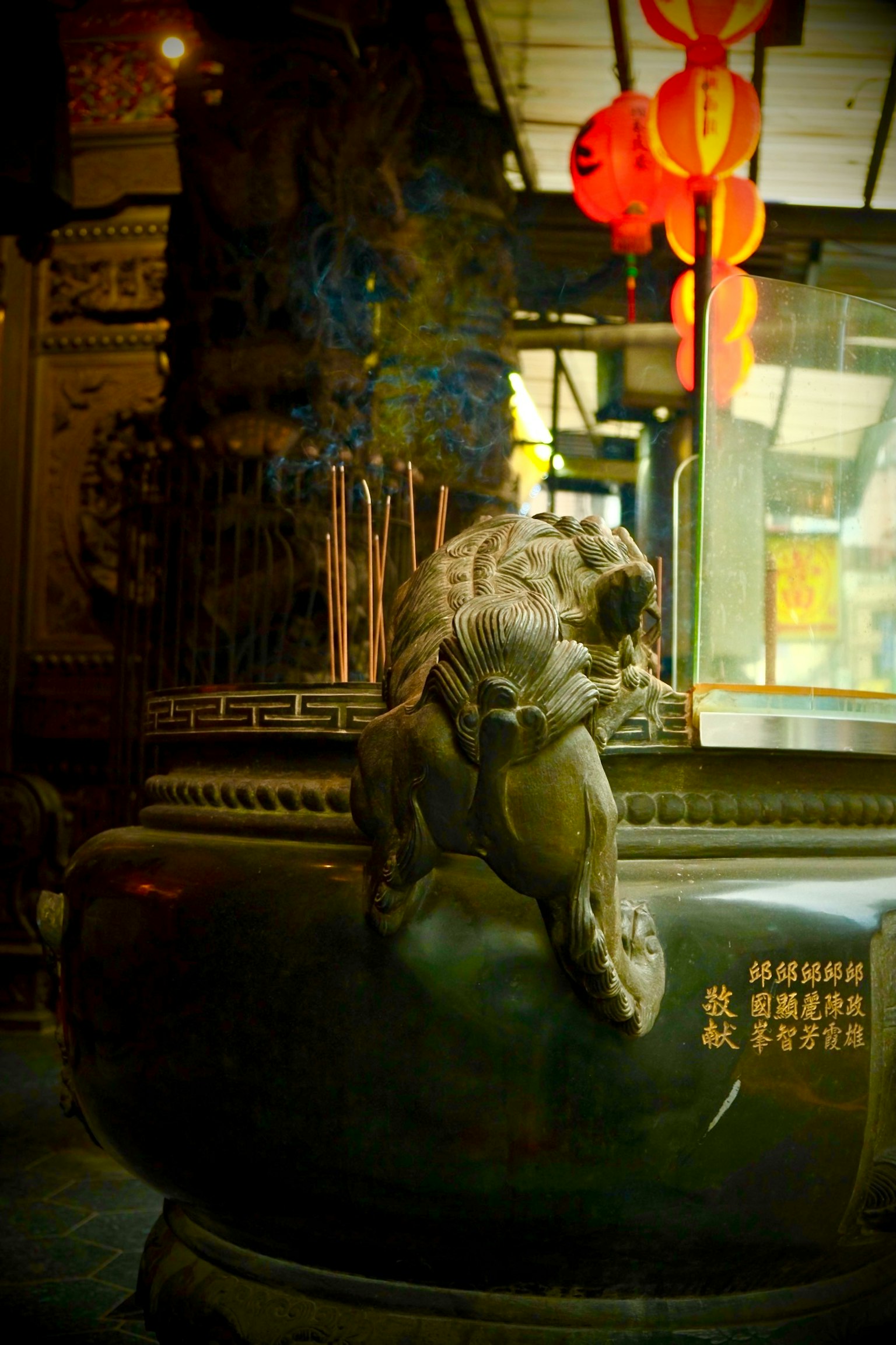 Lion sculpture and incense burner in a Chinese temple setting
