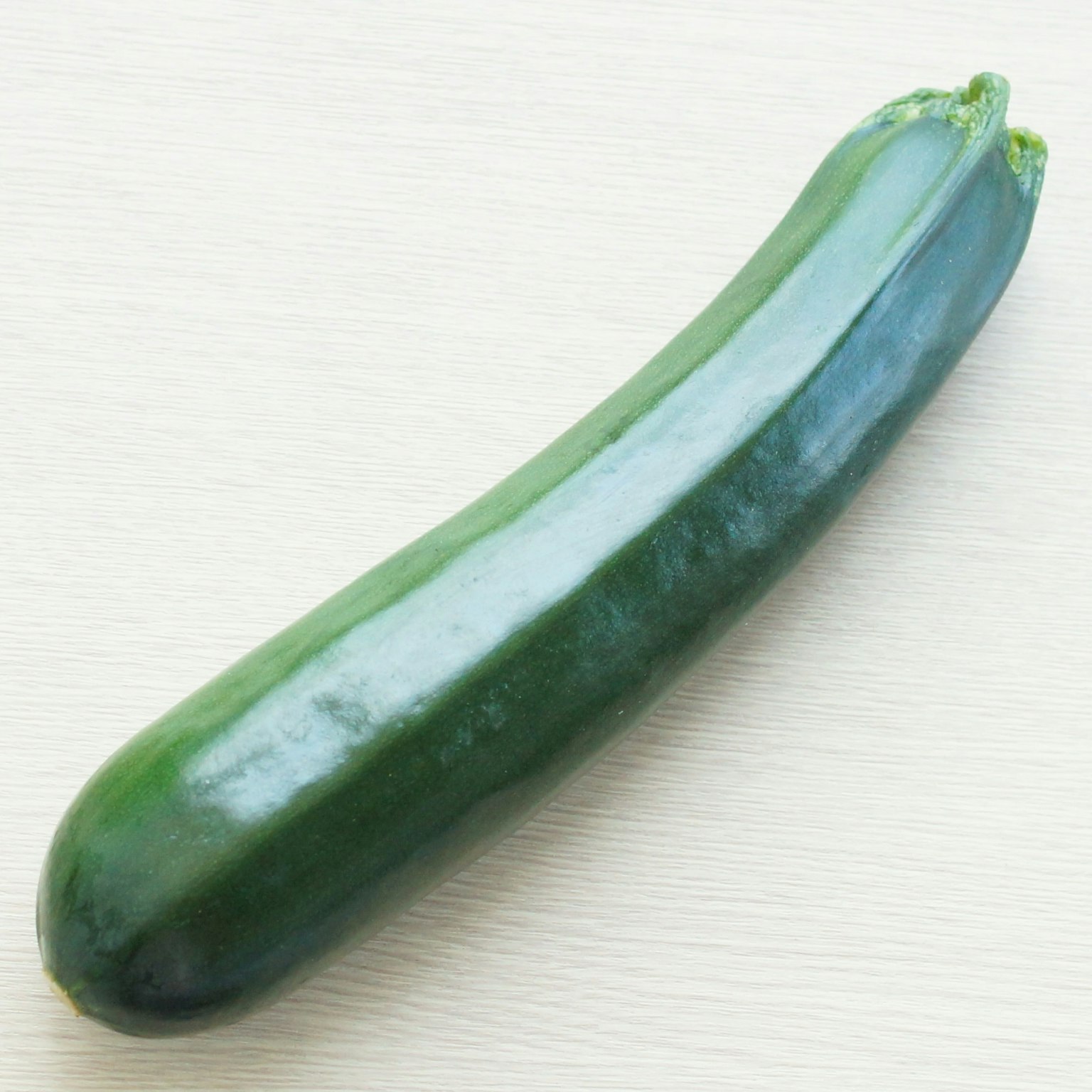 一根綠色的 zucchinis 放在平坦的表面上