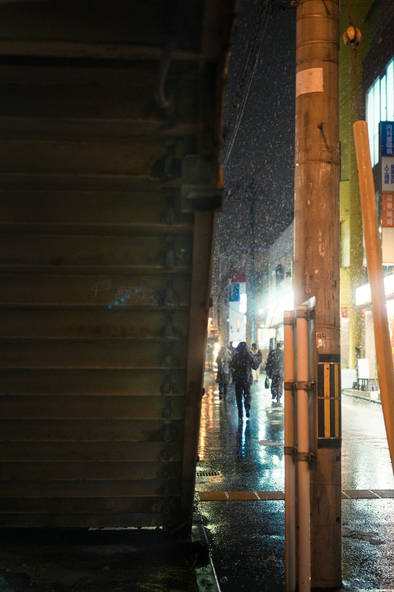 밤에 눈 속에서 걷는 사람들과 가로등