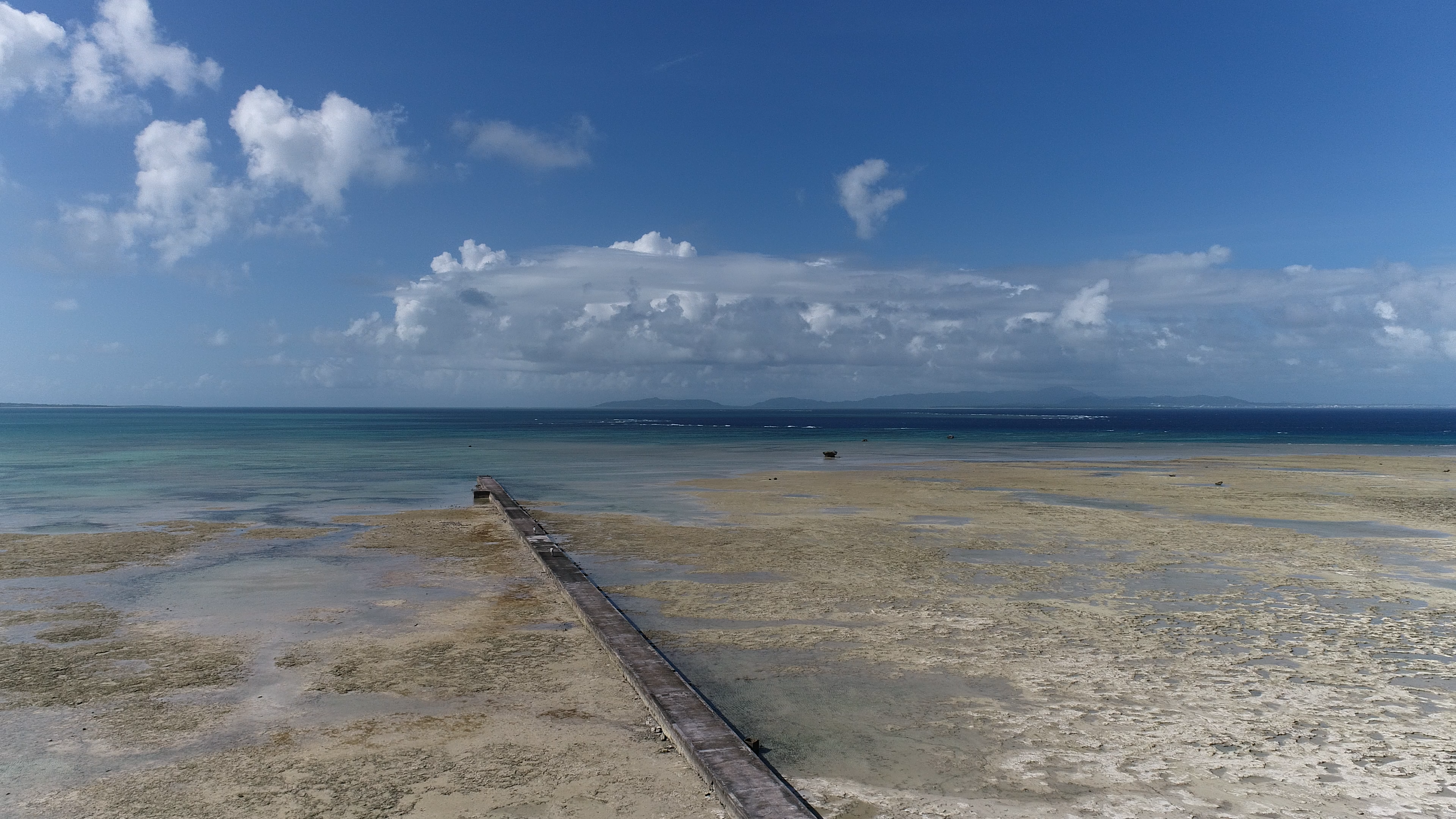 Pemandangan indah laut dan langit biru dengan dermaga di sepanjang pantai