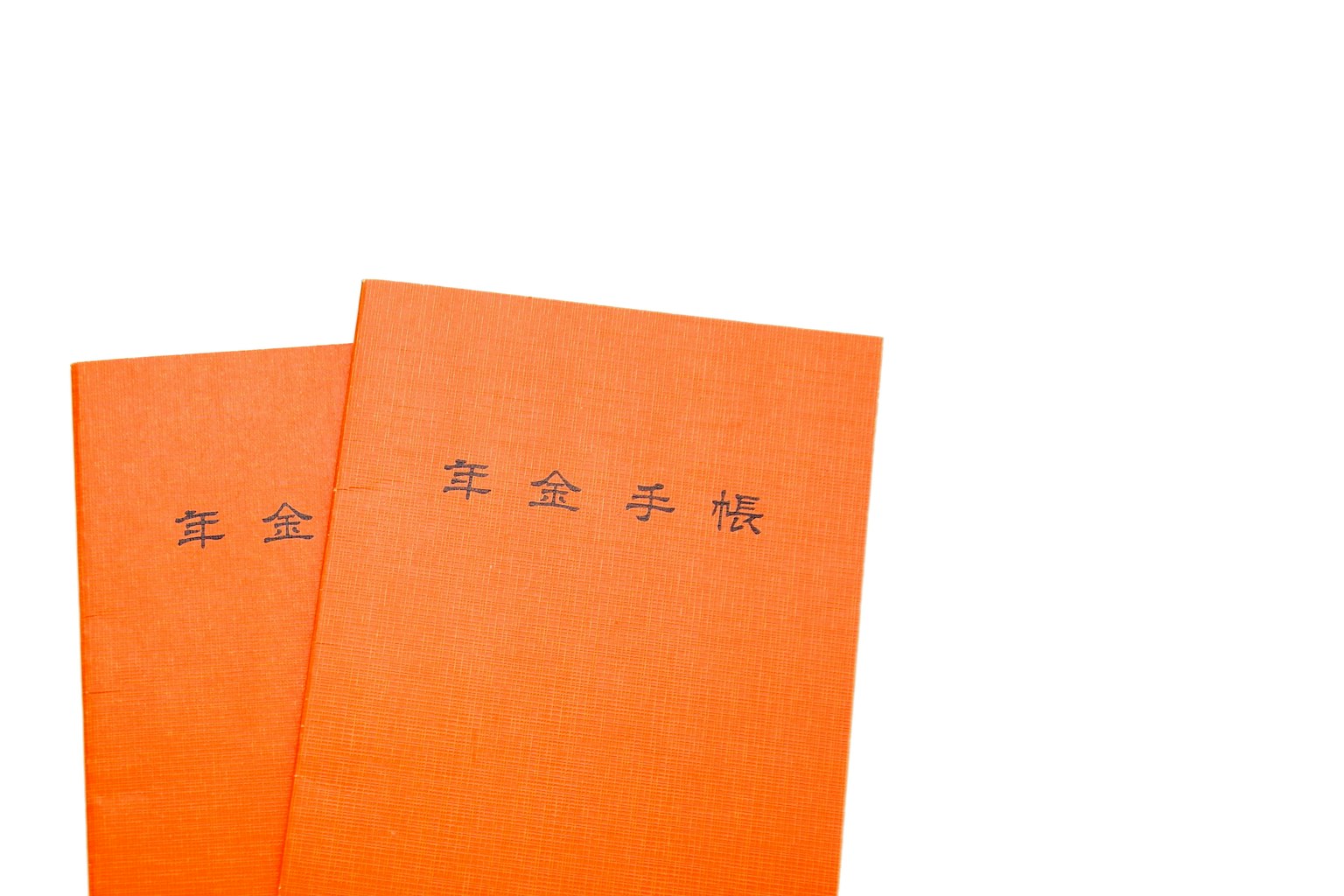 兩本重疊的橙色筆記本，封面上有中文字符