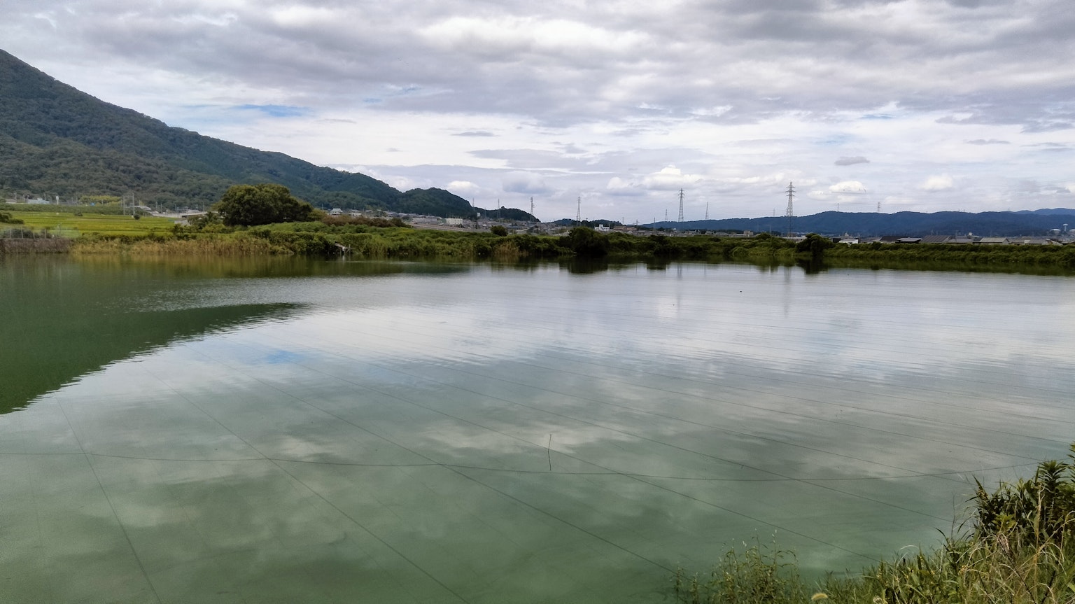 Superficie tranquila del lago con un entorno verde