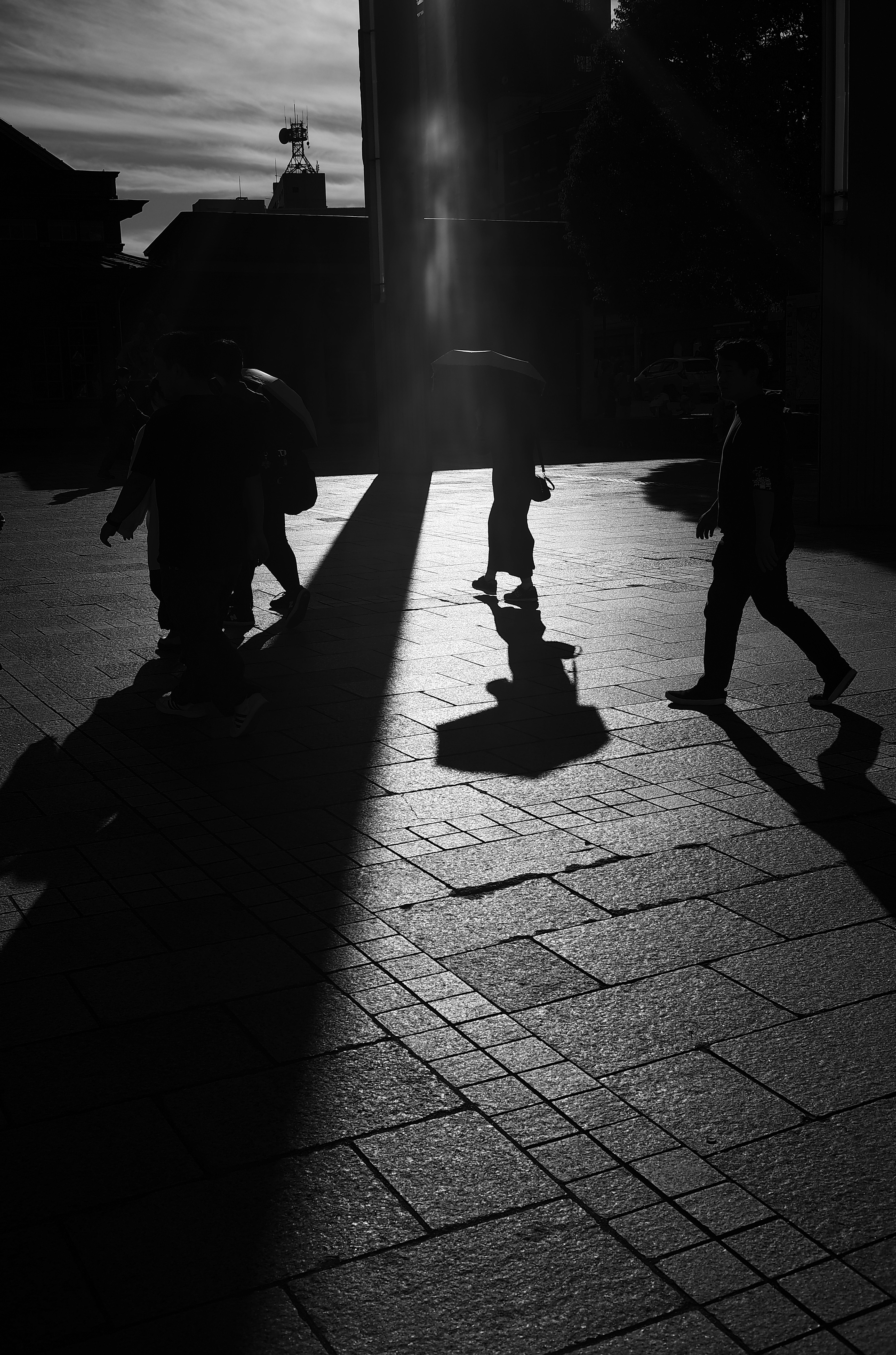 silhouettes of people walking in a twilight alley