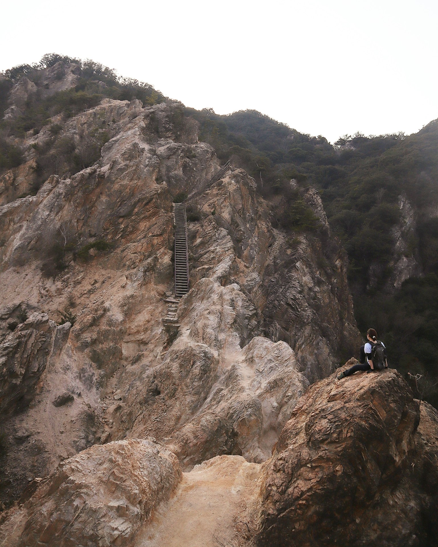 Personne assise sur un paysage montagneux accidenté