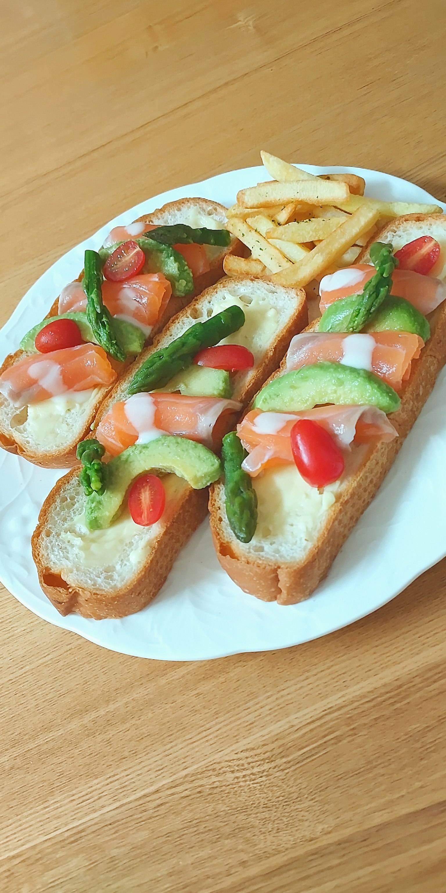 Geröstetes Baguette mit Tomaten und Spargel serviert mit Pommes