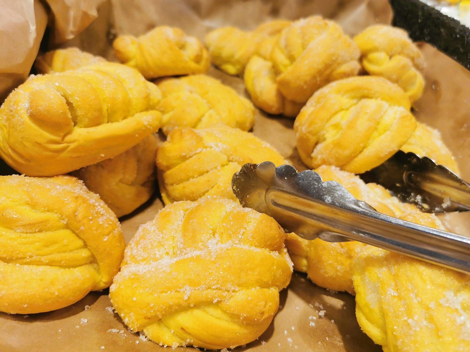 Panini dolci gialli intrecciati disposti su un vassoio