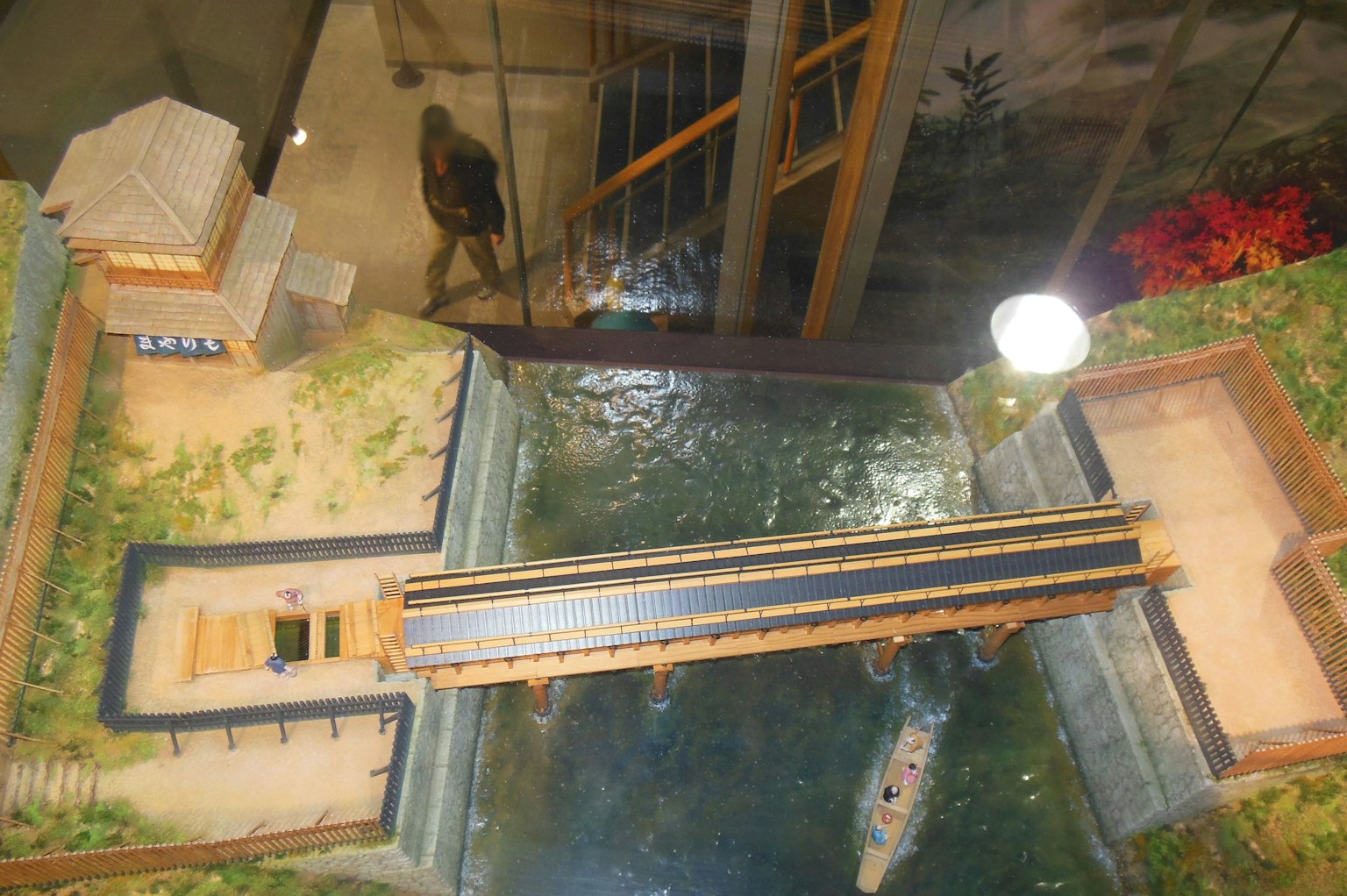Luftaufnahme eines Modells mit einer Brücke über Wasser und umgebender grüner Vegetation