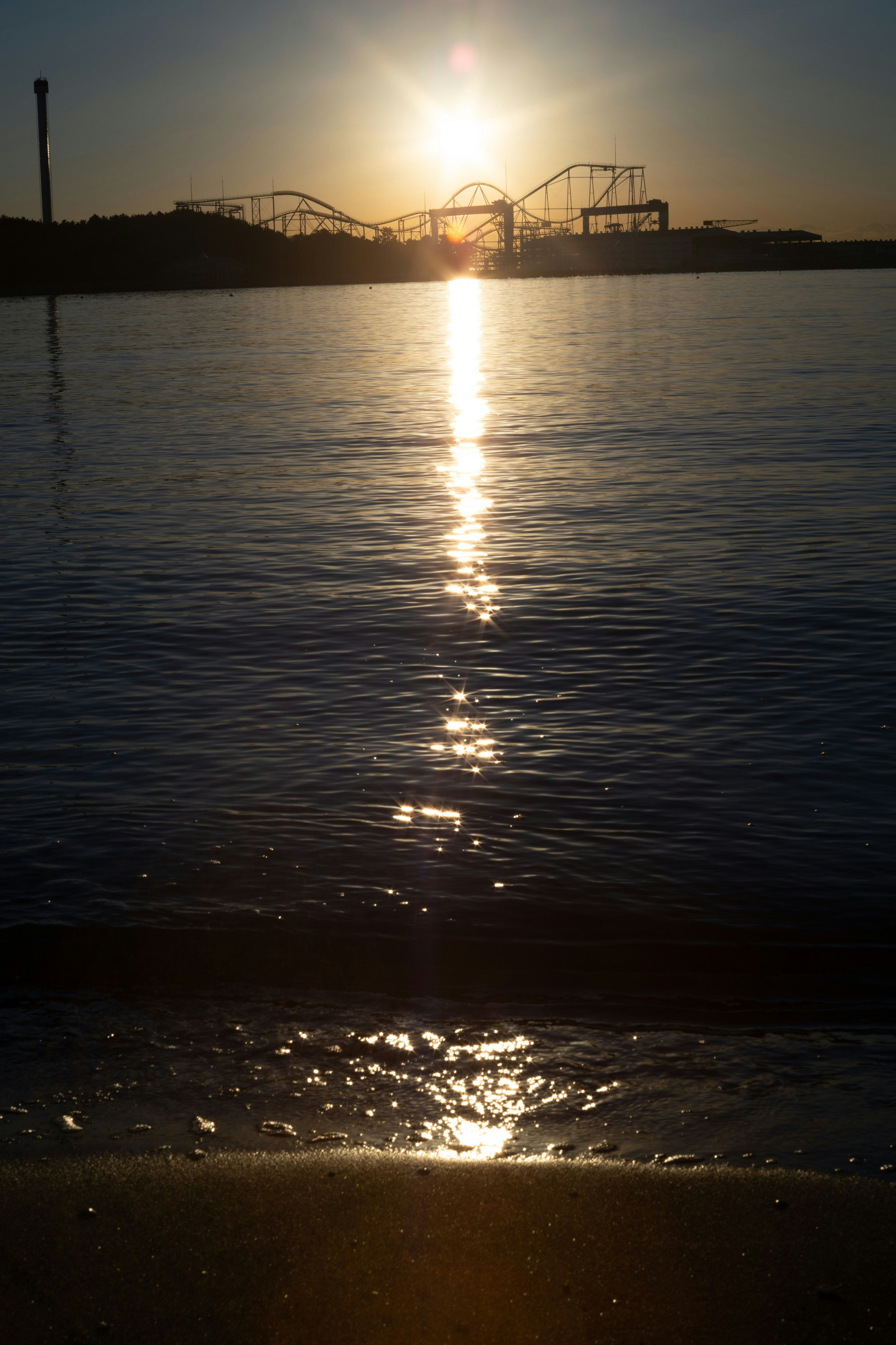 夕日に照らされる海面と橋のシルエット