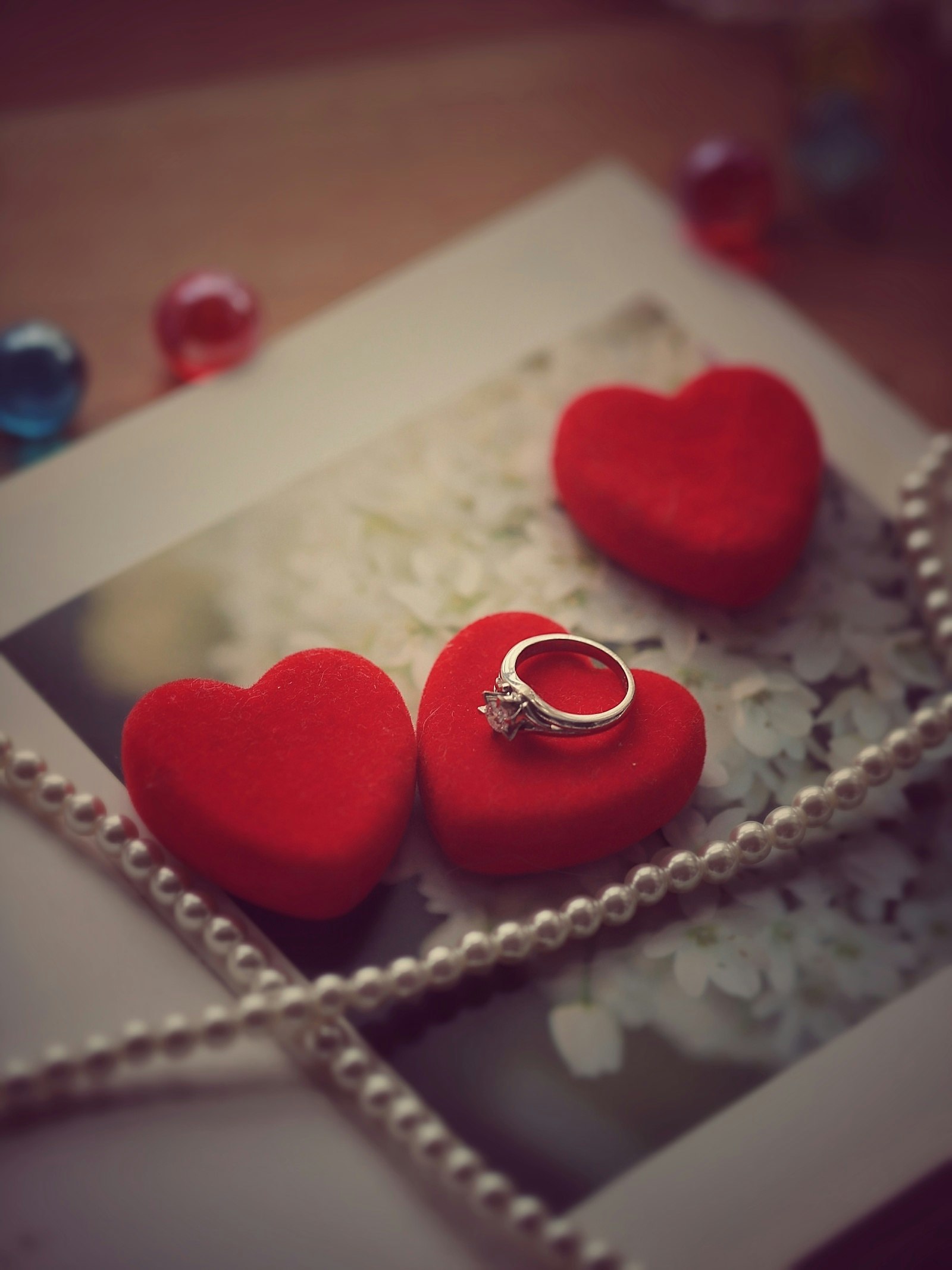 image of a gift box with heart-shaped rings and red heart decorations