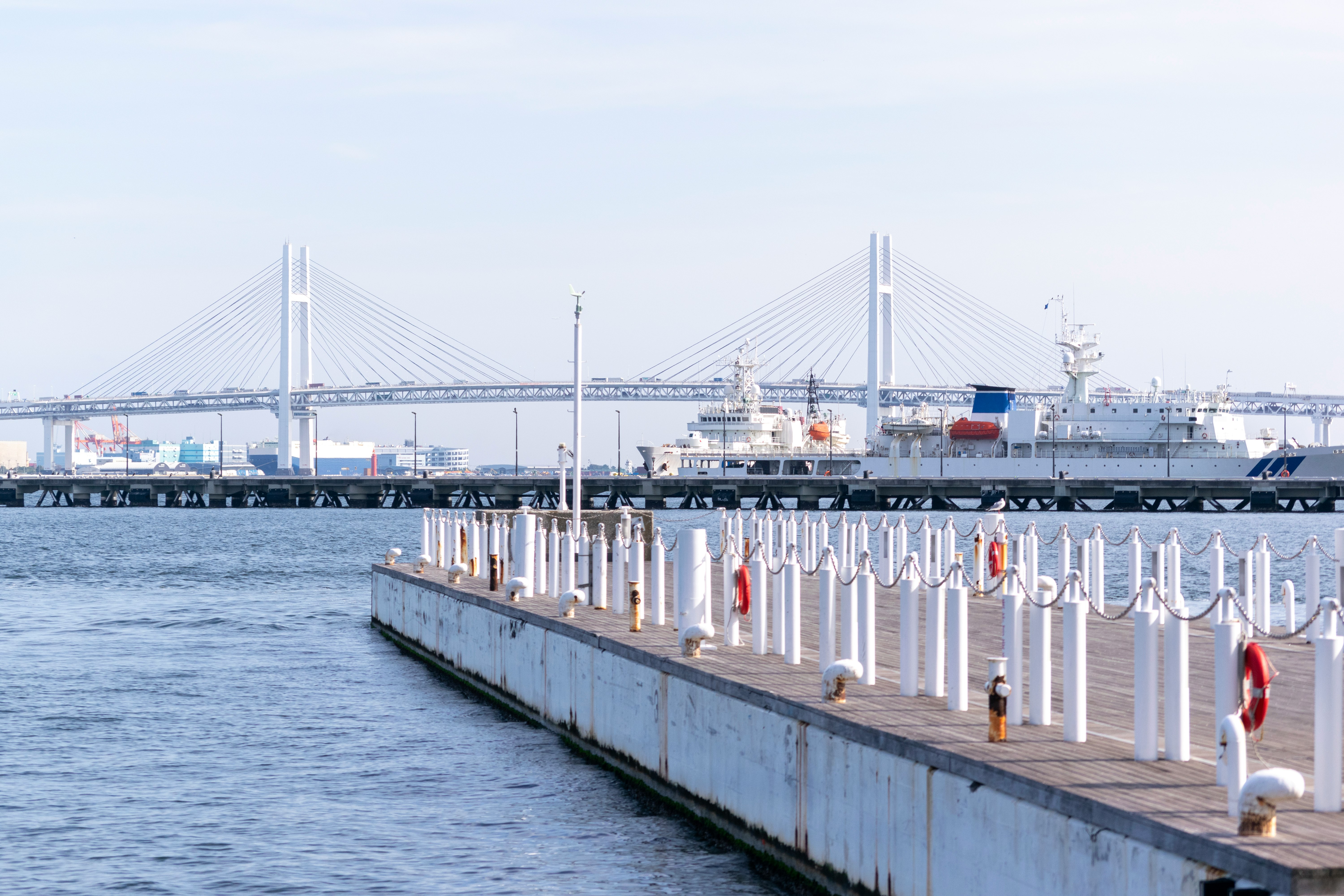 海沿いの桟橋と港の船舶が並ぶ風景