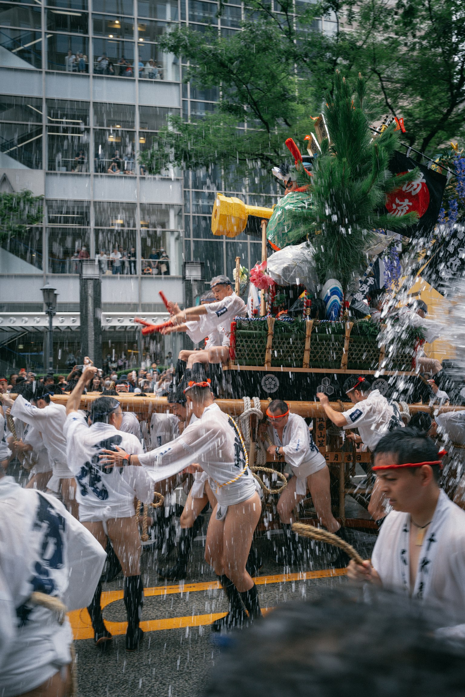 Participants carrying a portable shrine while splashing water during a festival