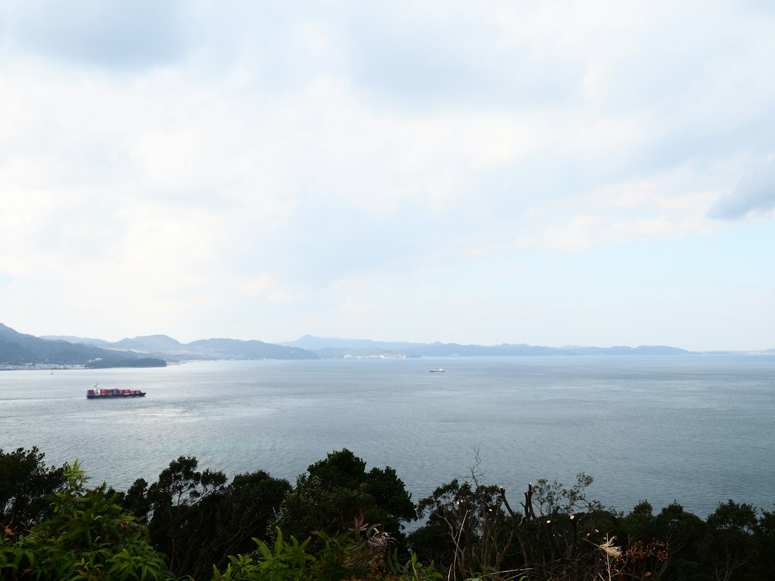 宁静的海景和多云的天空远处可见一艘船