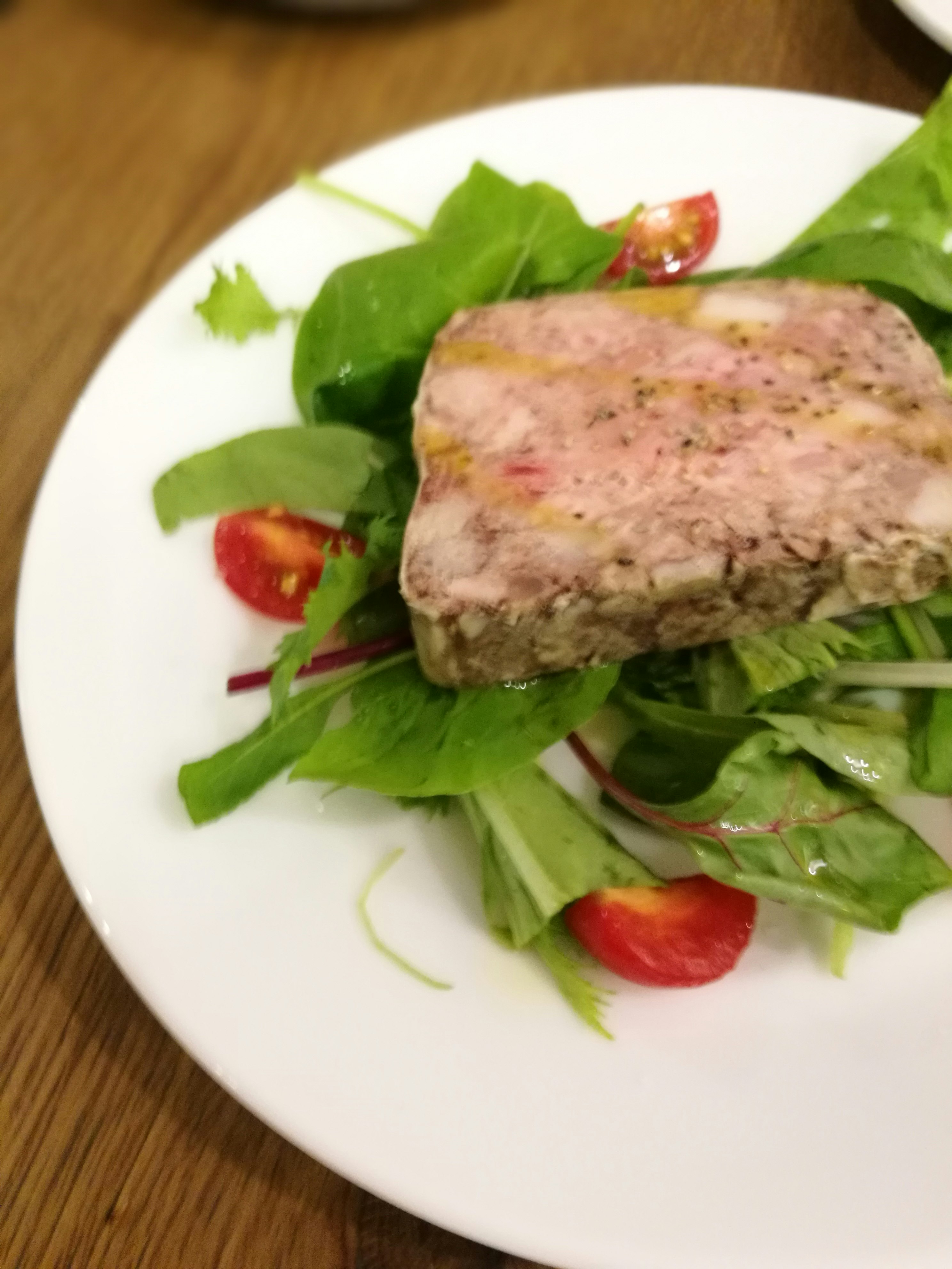 木桌上的沙拉与肉类冻/肉酱卷
