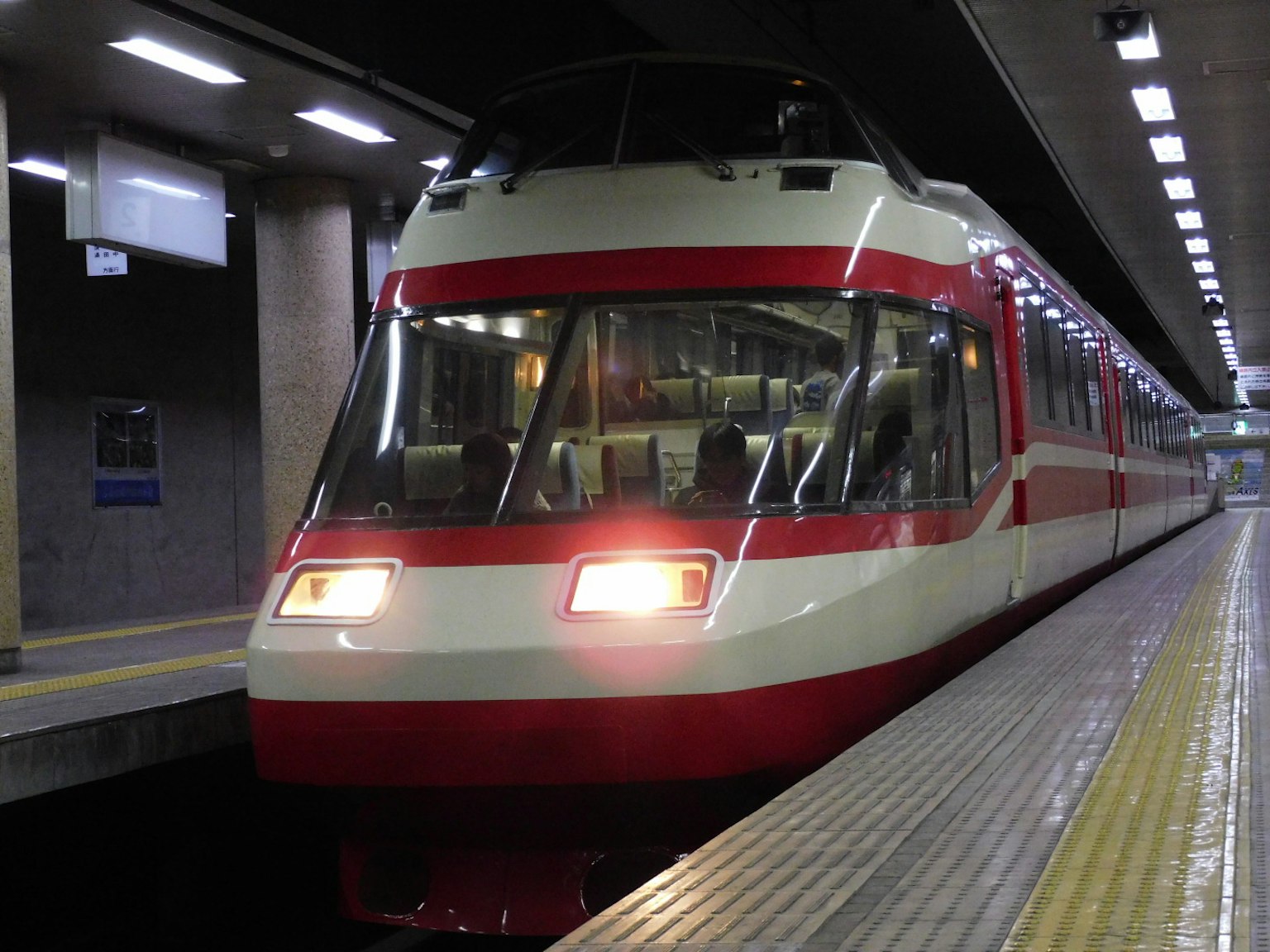 Treno rosso e bianco fermo sulla piattaforma della stazione