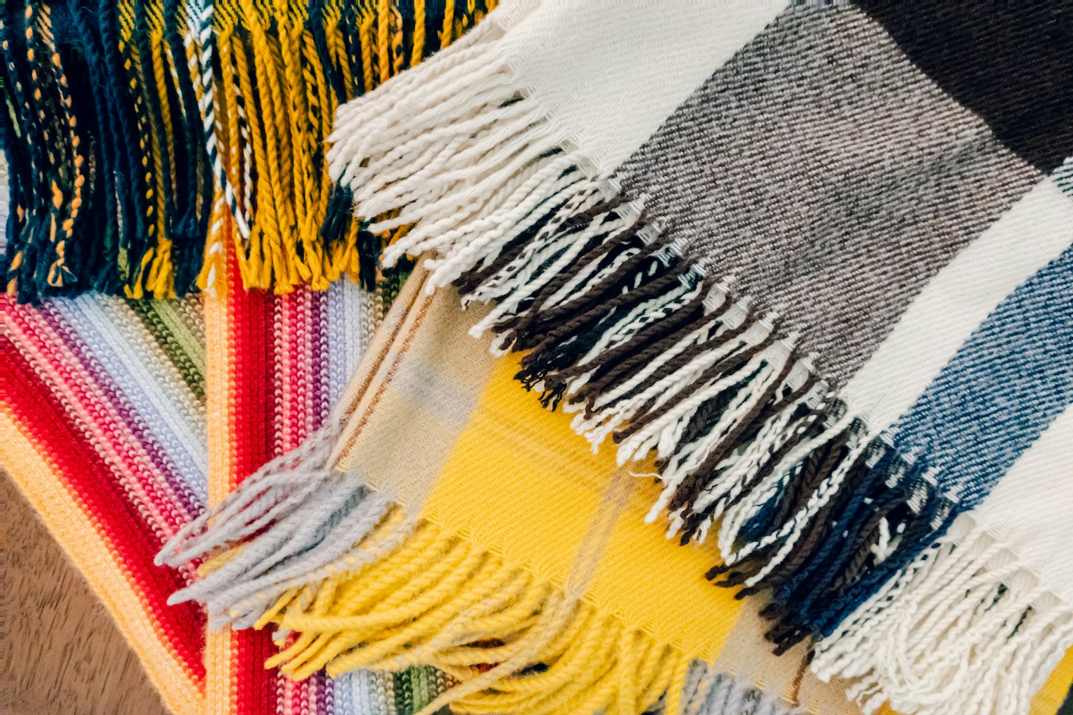 Une pile d'écharpes colorées avec des franges