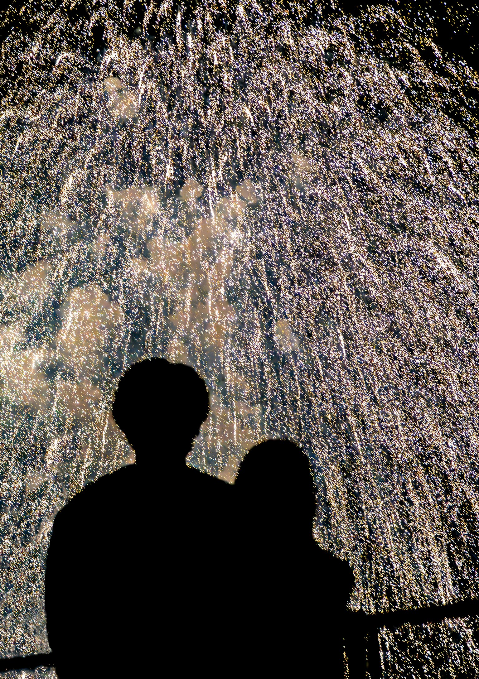 Silueta de una pareja frente a un espectáculo de fuegos artificiales