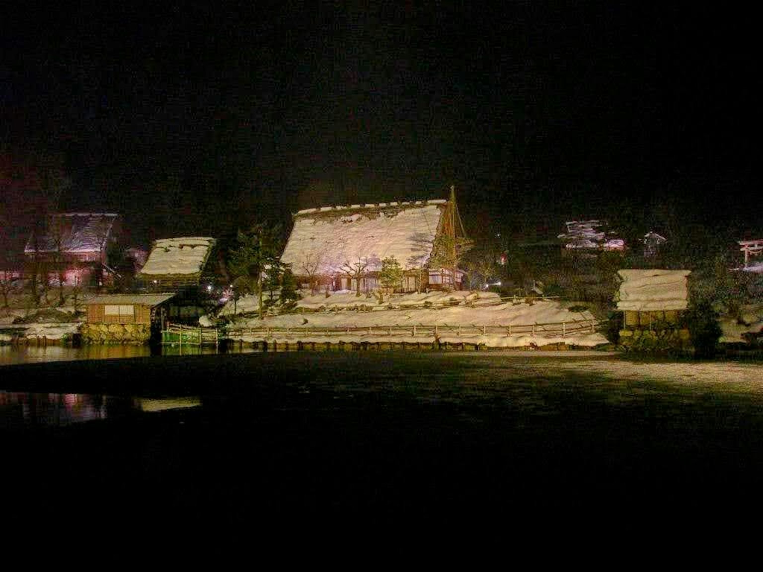 Traditionelle Gebäude bei Nacht beleuchtet mit Reflexionen im Wasser
