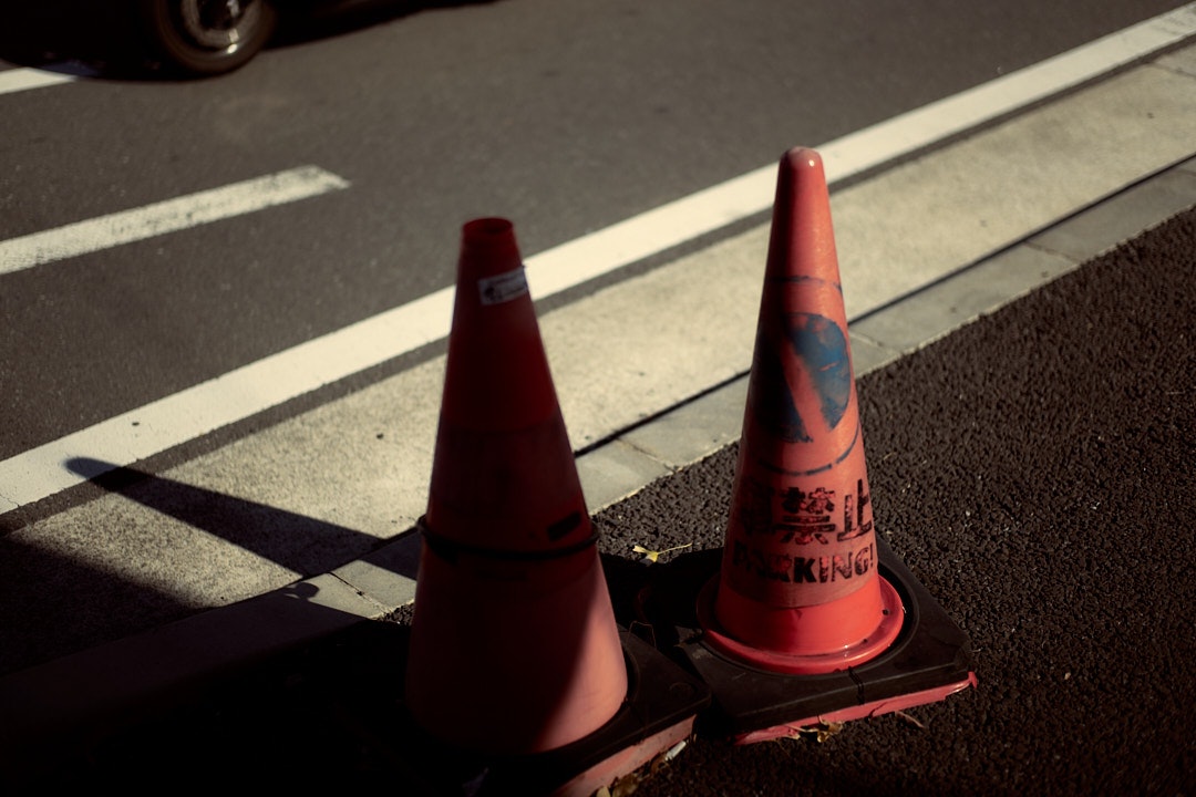 道路の白線のそばに置かれたコーンと交通規制の目印
