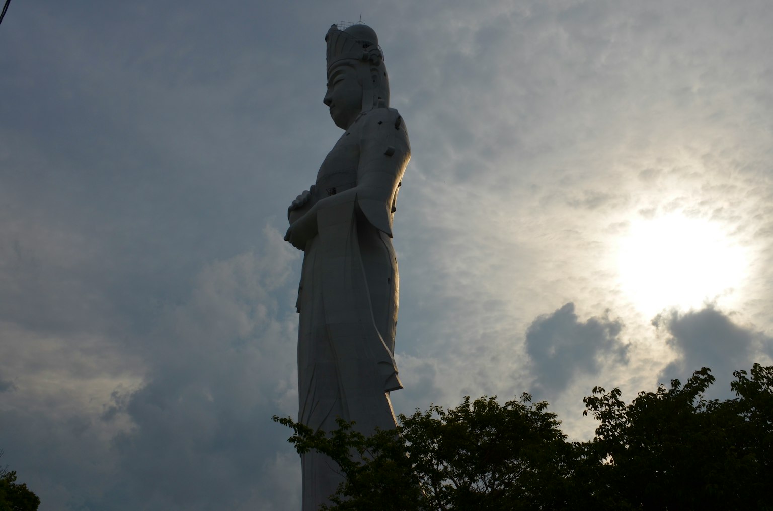 Silueta de una estatua blanca de pie contra el cielo