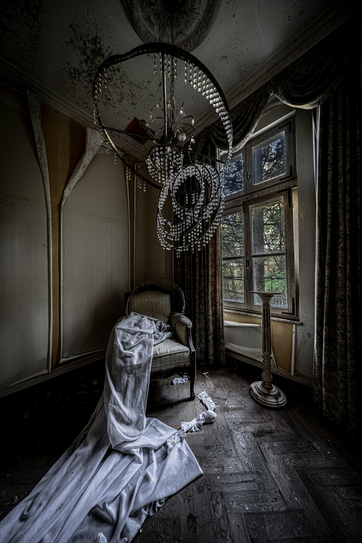薄暗い部屋に置かれた椅子とシャンデリア 窓からの自然光が差し込む