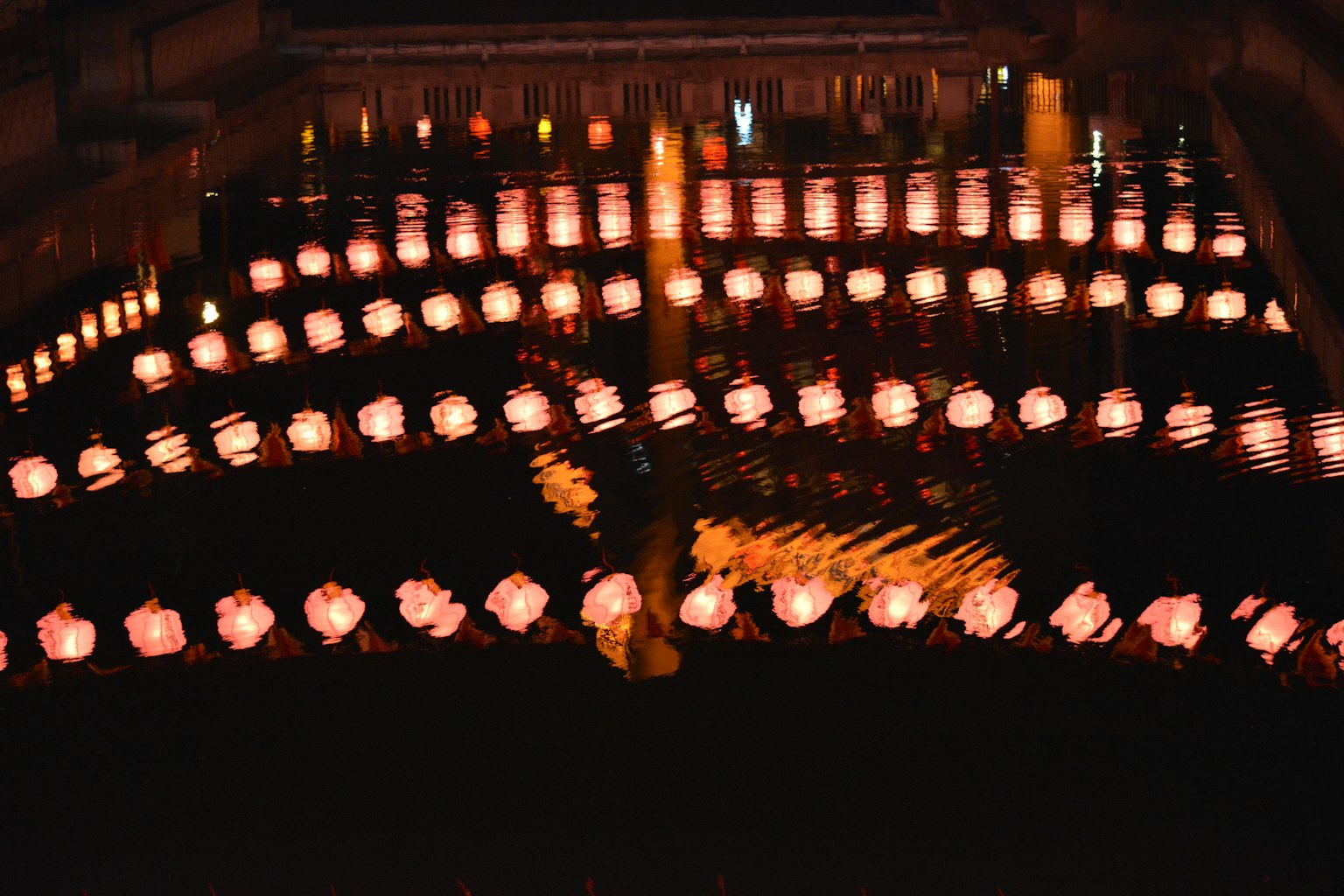 Beautiful view of lanterns reflecting on the water at night