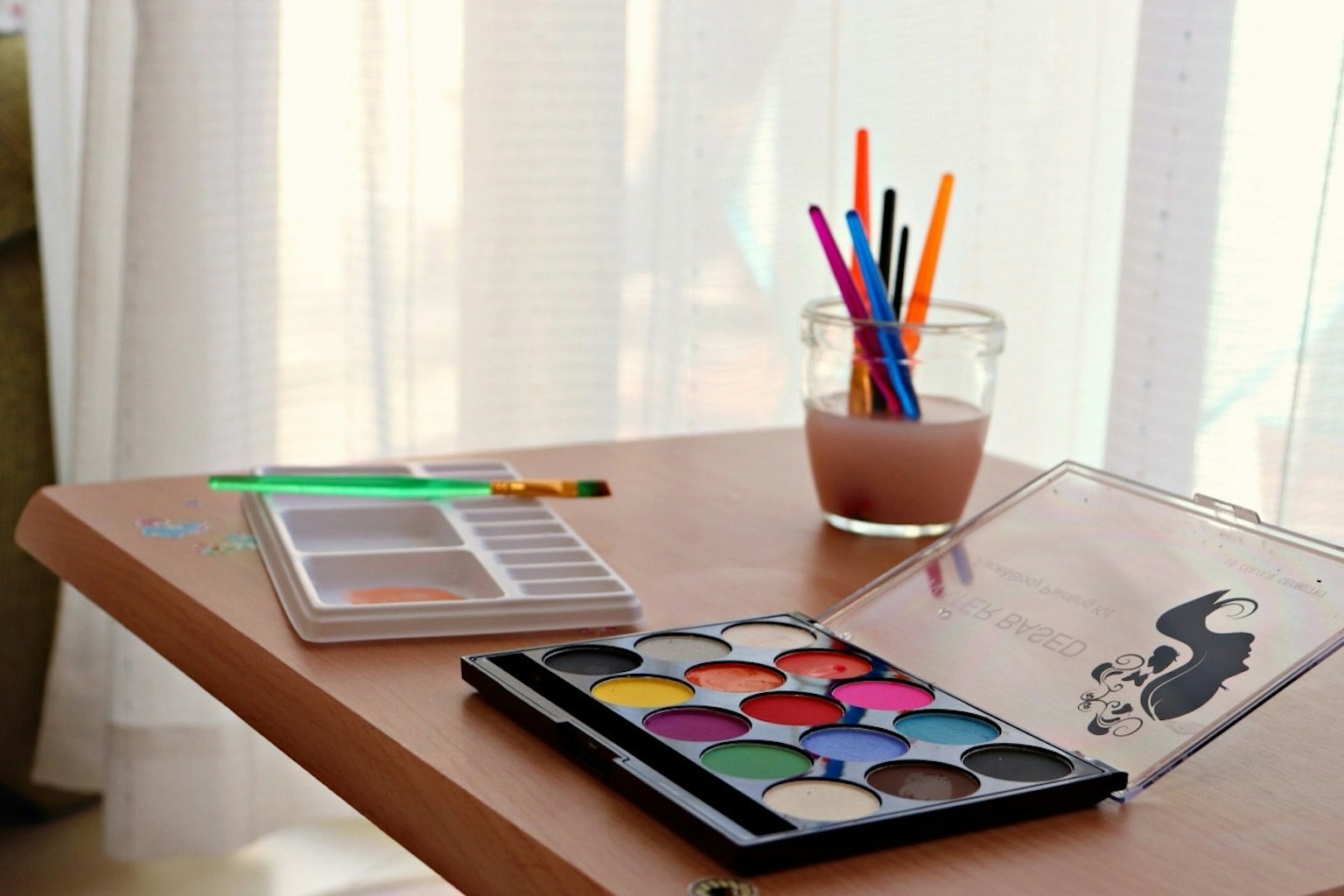 Colorful paints and stationery arranged on a table