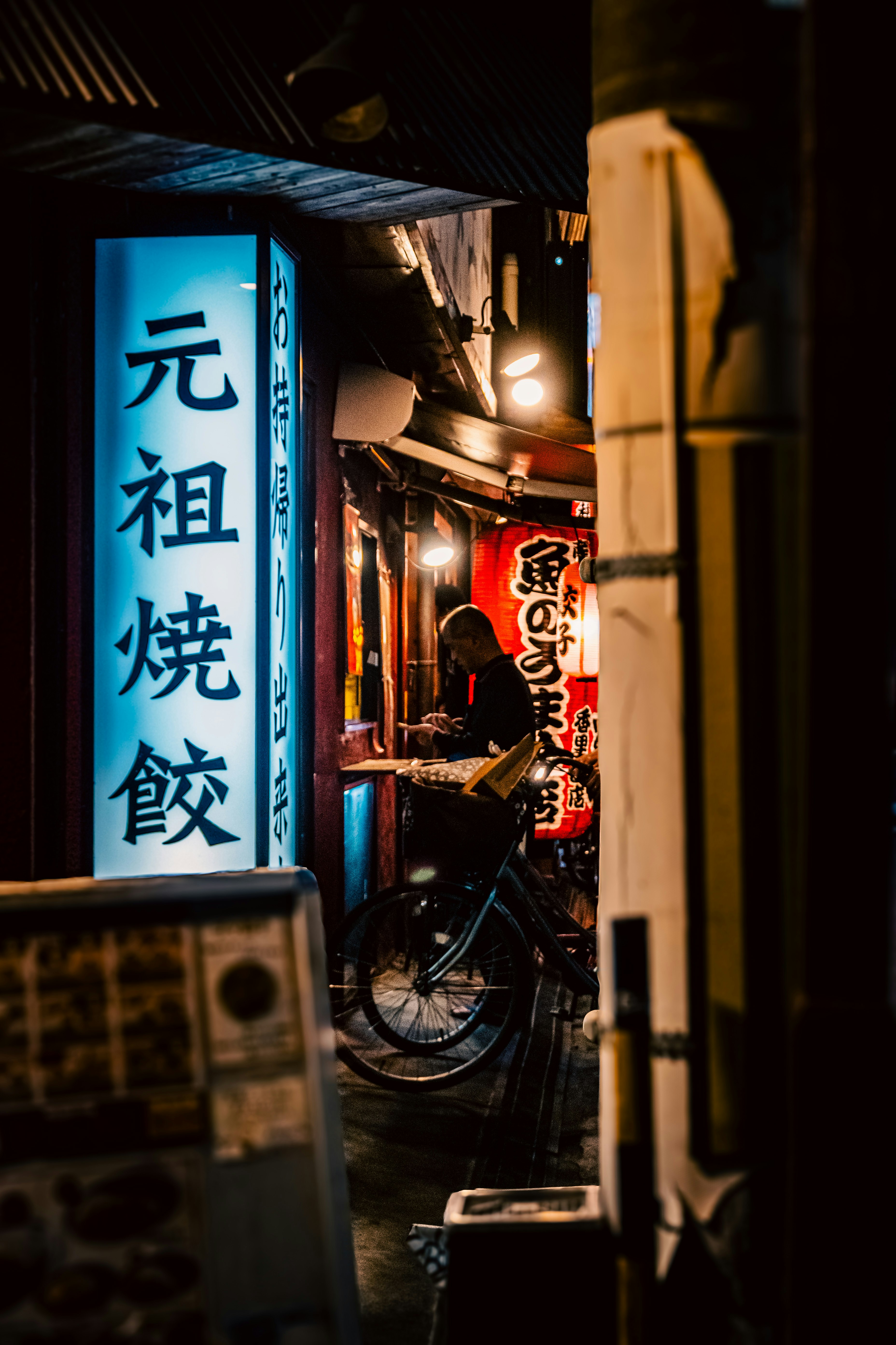 路地の提灯と自転車が並ぶ夜の商店街の軒先