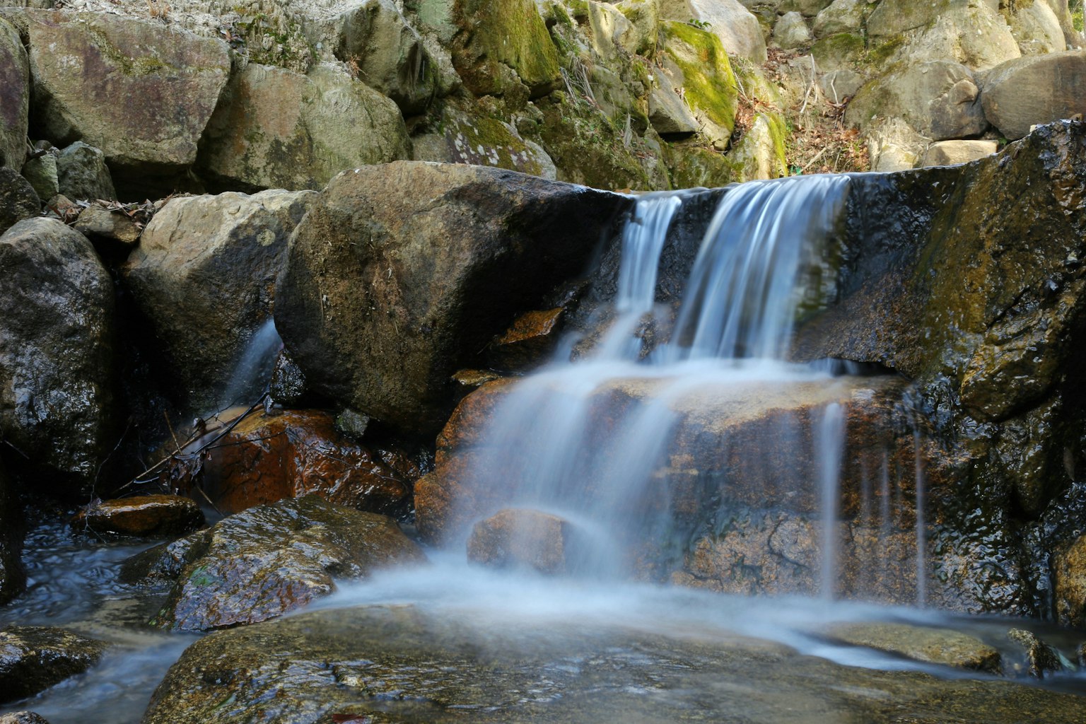 Eine schöne Szene eines kleinen Wasserfalls, der zwischen den Felsen fließt