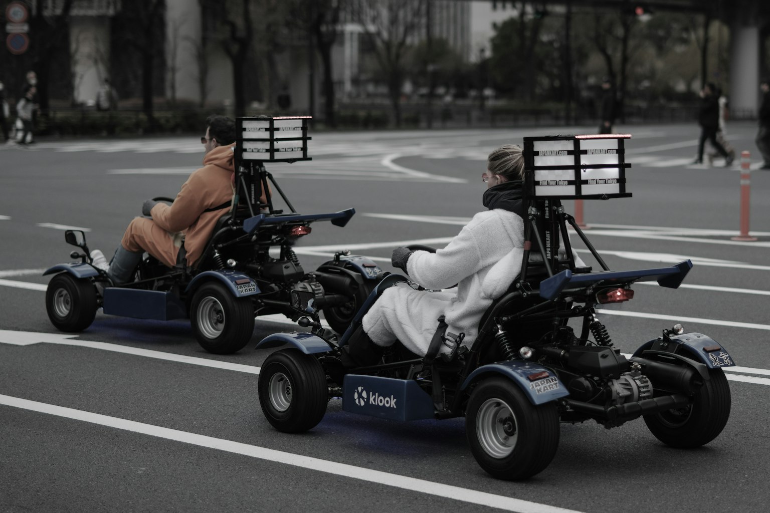 Due persone che guidano go-kart in una strada cittadina