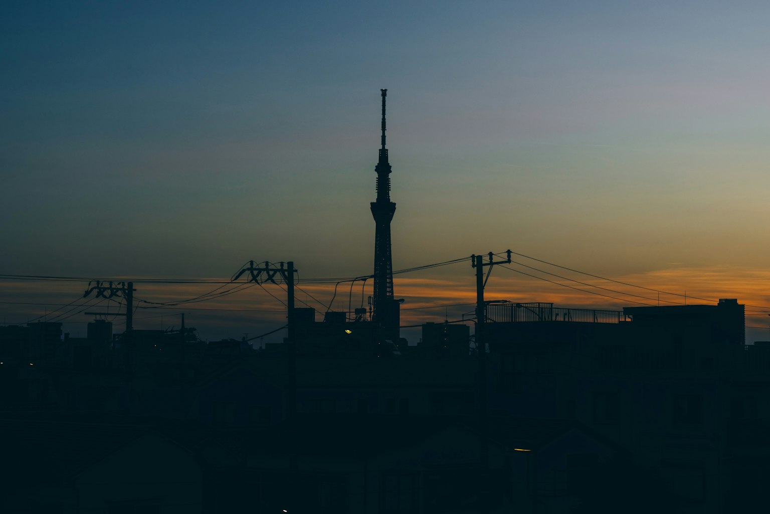 Silhouette of Tokyo Skytree against a sunset sky with city skyline