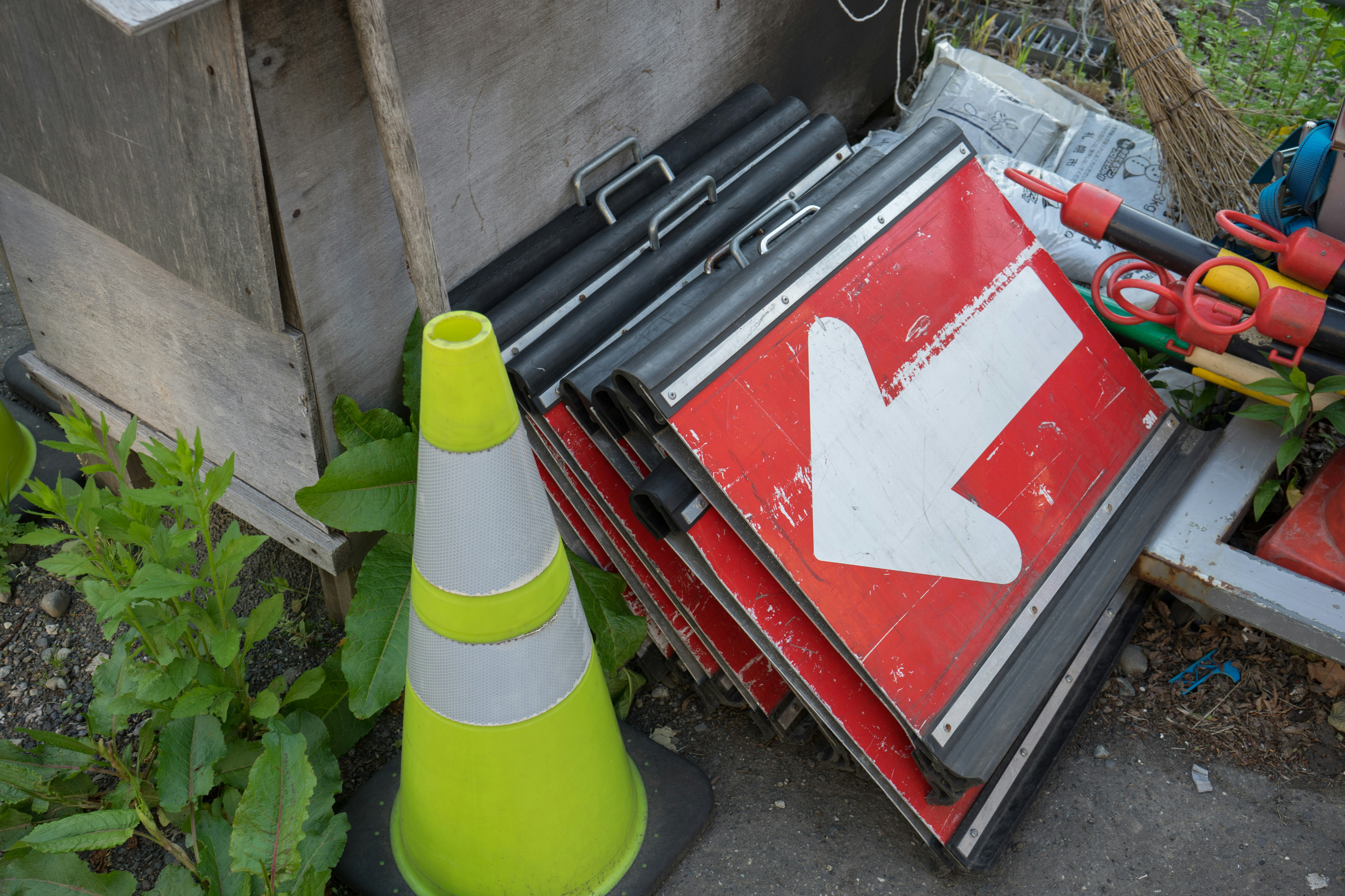 Red toolbox and plumbing parts beside potted plants