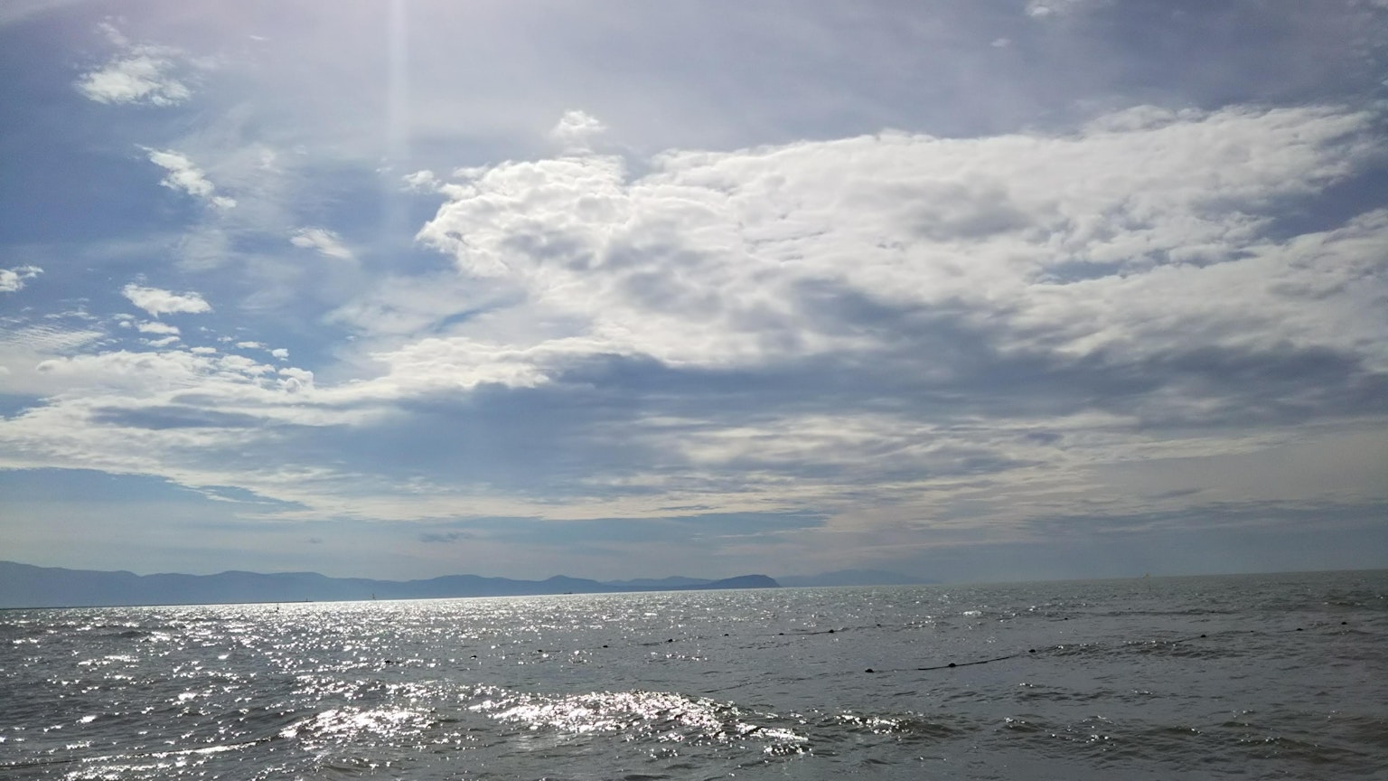 Vista escénica del océano azul y cielo nublado