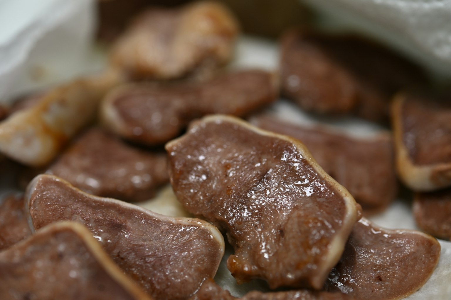 肉の断片が白い布の上に散らばっている