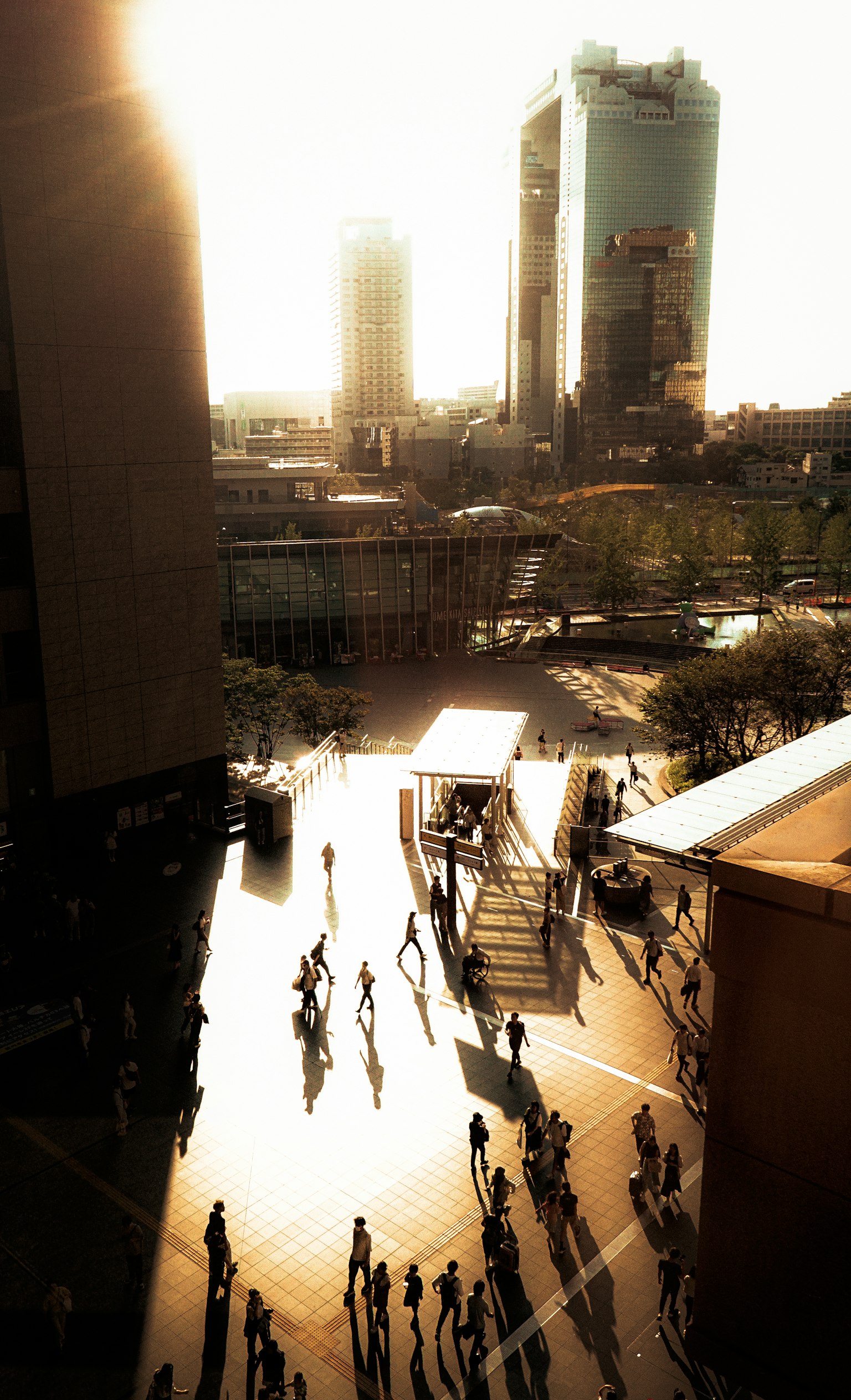 Paisaje urbano con personas caminando al atardecer