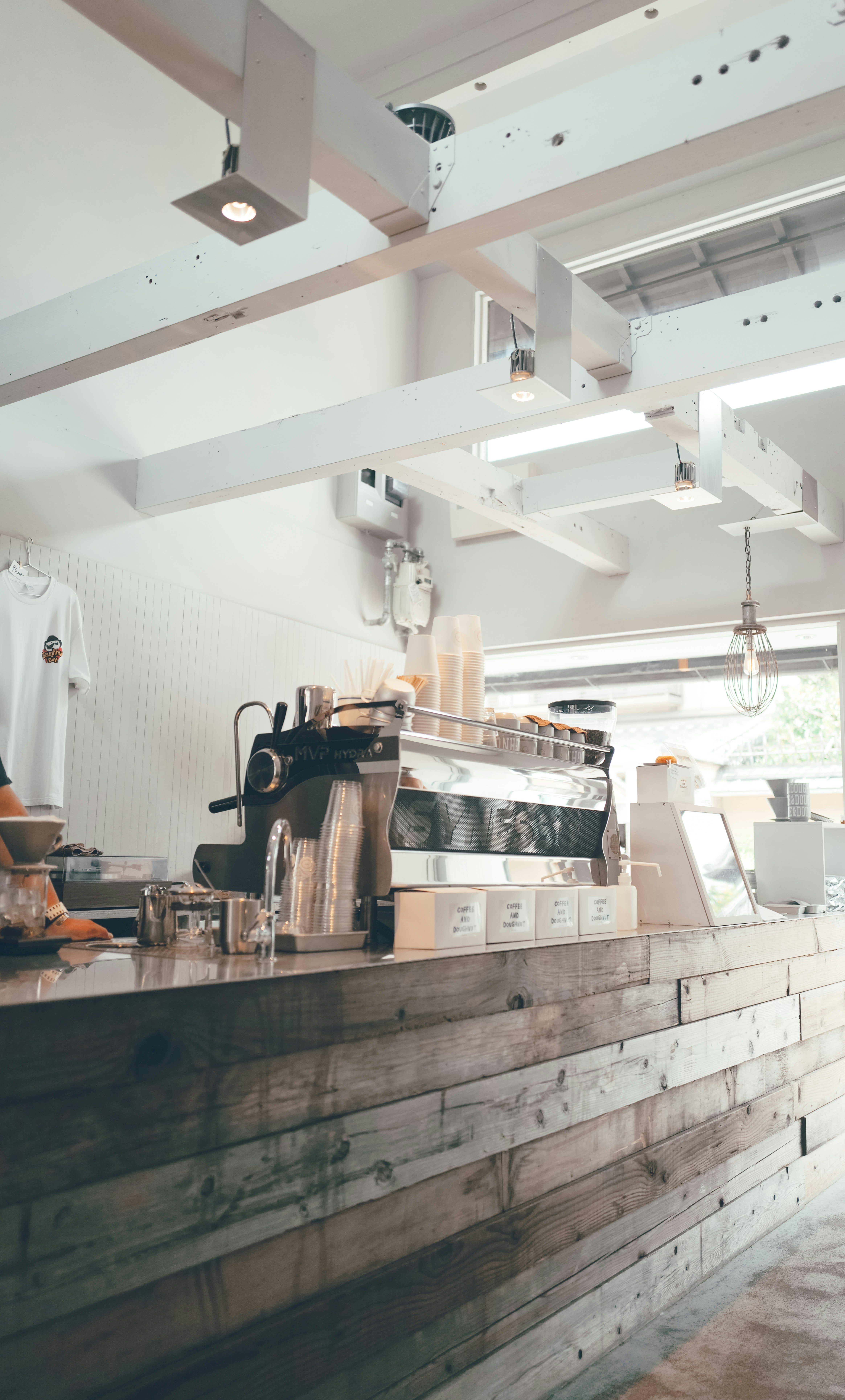 barista equipment and display case inside a cafe with a wooden counter