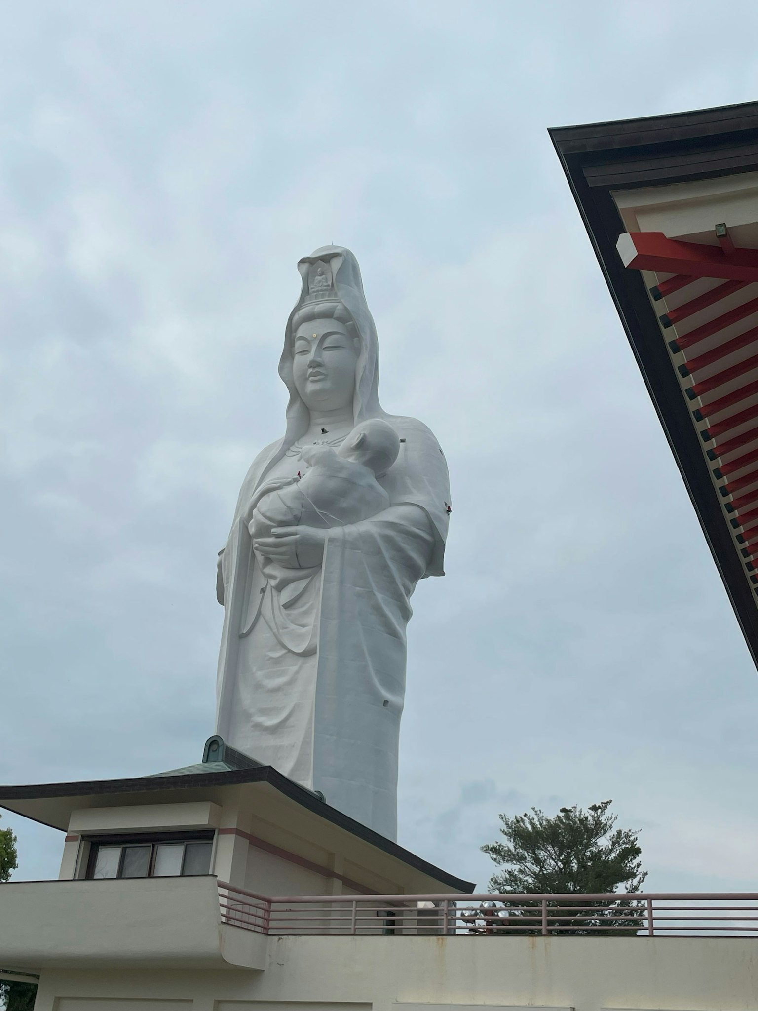 Patung Kuan Yin putih tinggi mengawasi area