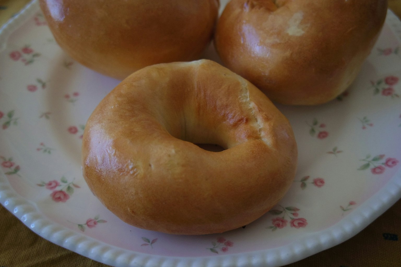 Bagel yang baru dipanggang di atas piring putih dekoratif