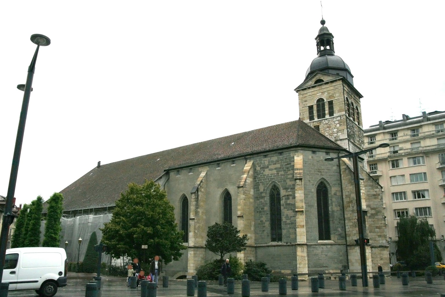 Église en pierre grise avec des arbres verts autour