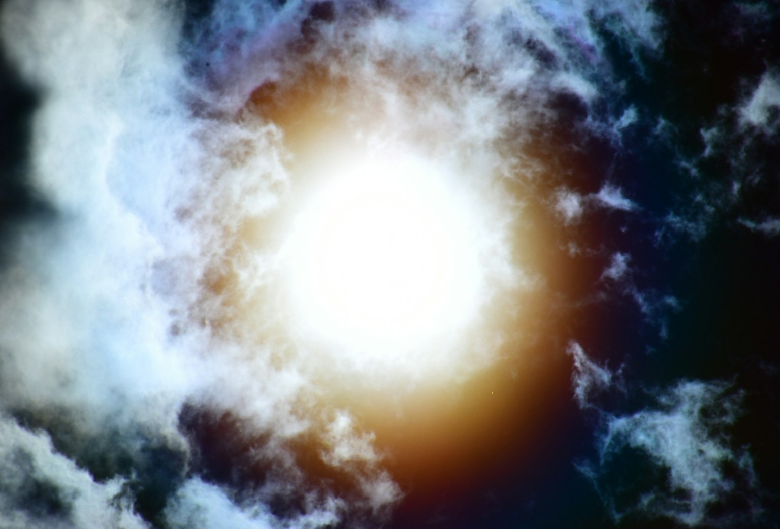 Sole luminoso circondato da un cielo blu e nuvole bianche