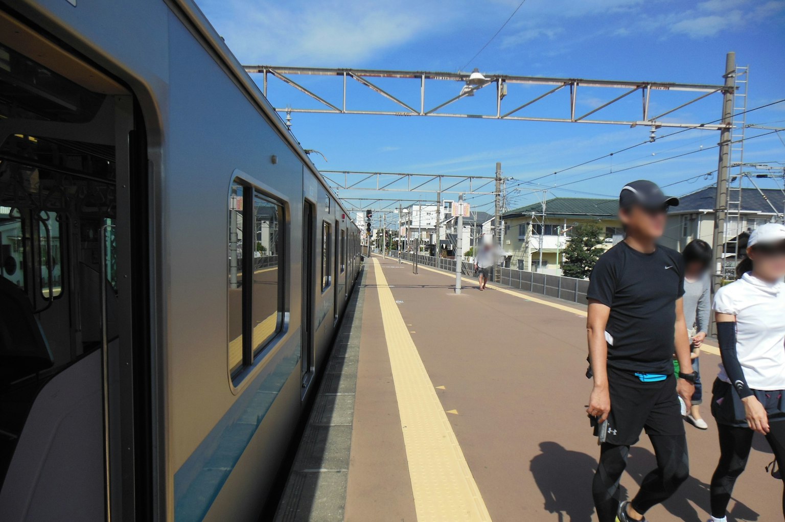 Des personnes marchant sur le quai de la gare à côté d'un train