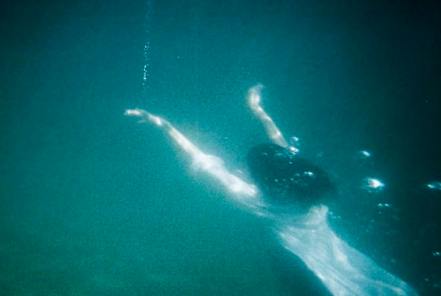 Une belle image de la silhouette d'une femme nageant sous l'eau
